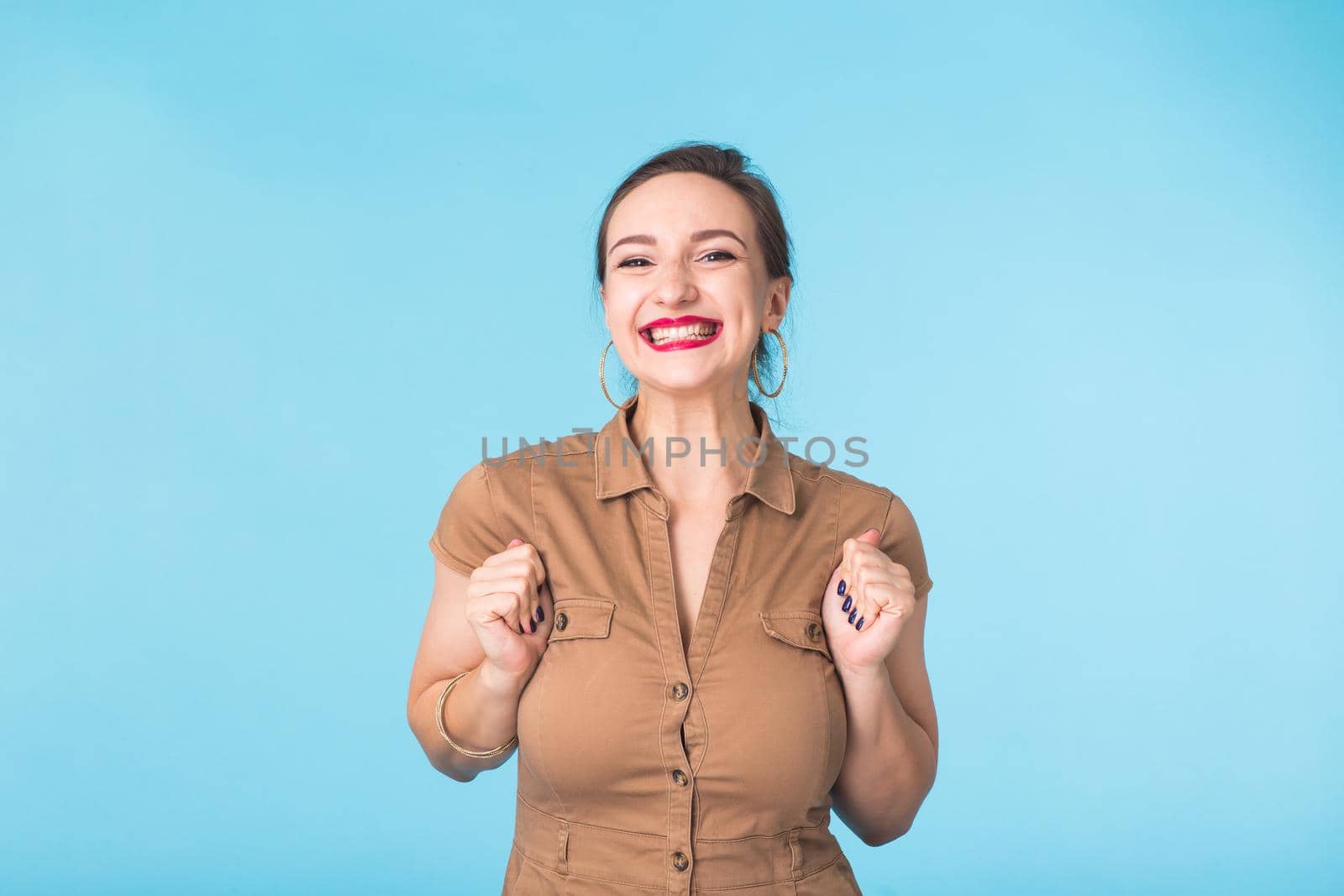 Portrait of young emotional woman cheerful smiling looking at camera. Isolated on pastel blue background. Copy space. by Satura86