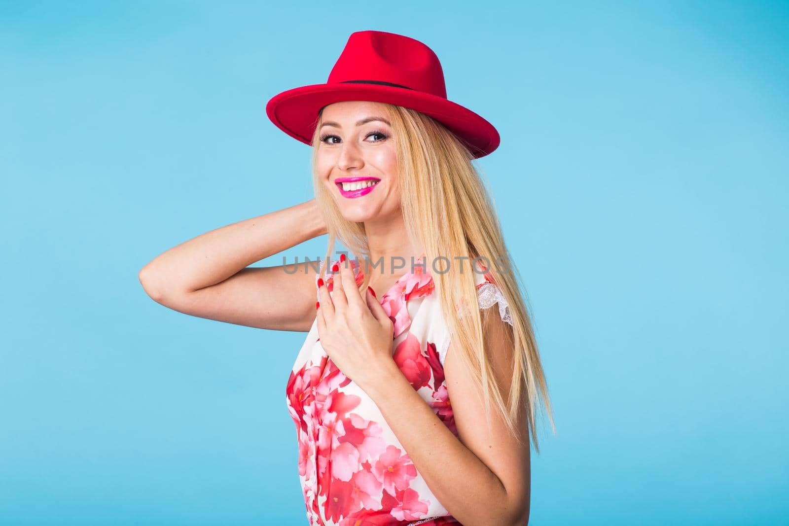 Portrait of happy cheerful smiling young beautiful blond woman on blue background.