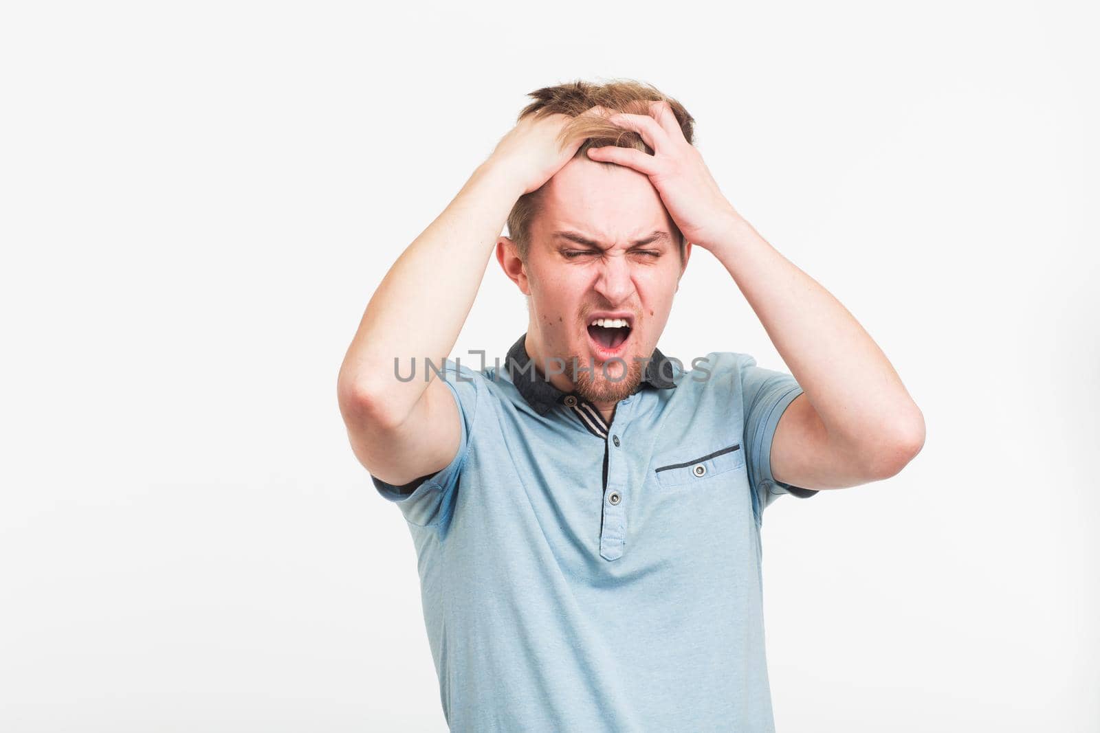 Stressed Young Man Clutching the Head in white background