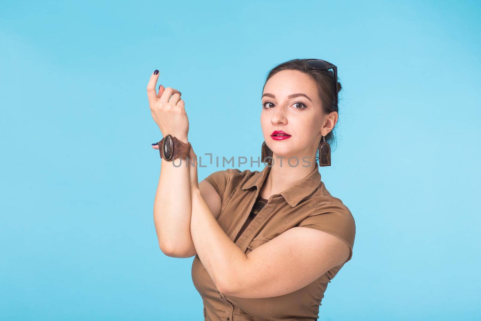 Portrait of young beautiful ginger woman with freckles cheerfuly smiling looking at camera. Isolated on pastel blue background. Copy space.