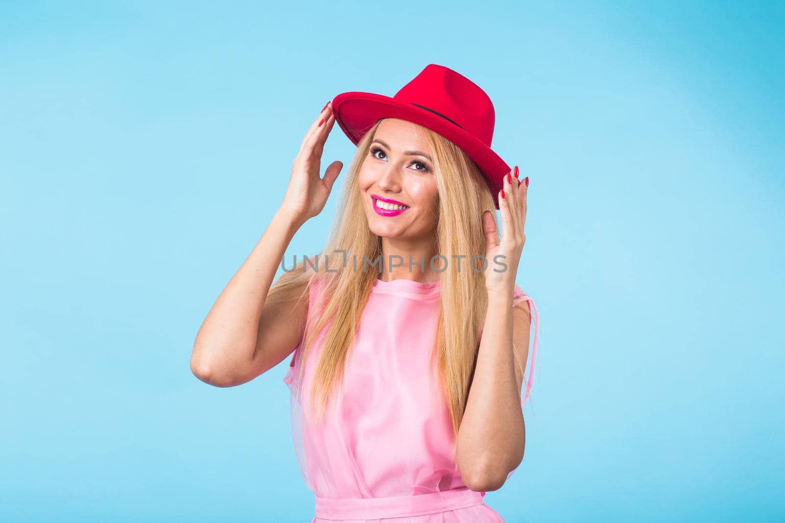 Portrait of smiling blonde woman in fashionable look on blue background. Style, fashion, summer and people concept.