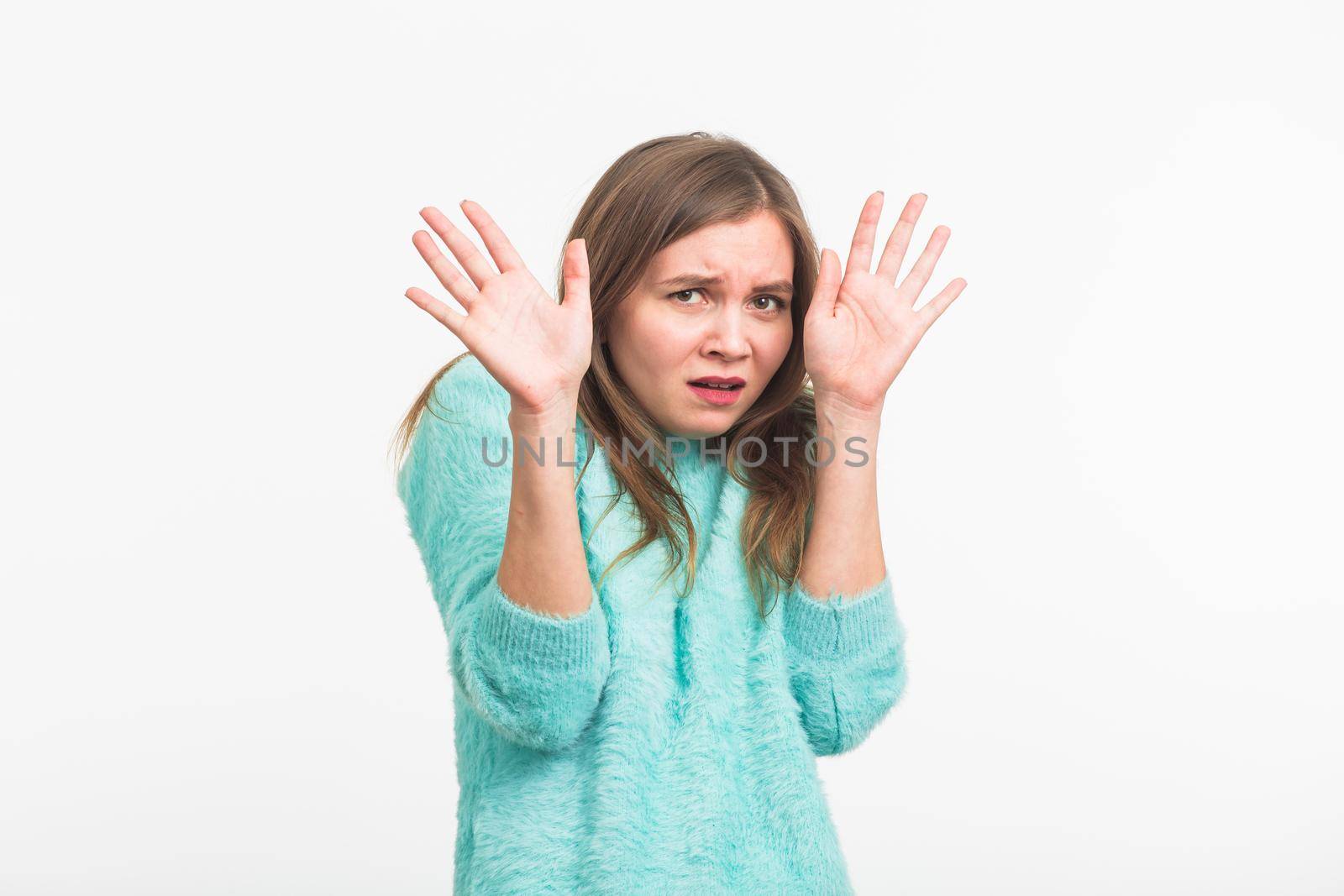 Scared stressful woman with bugged eyes looking terrified into camera. Fearful beautiful young female in casual clothes having bad reaction on horror news .