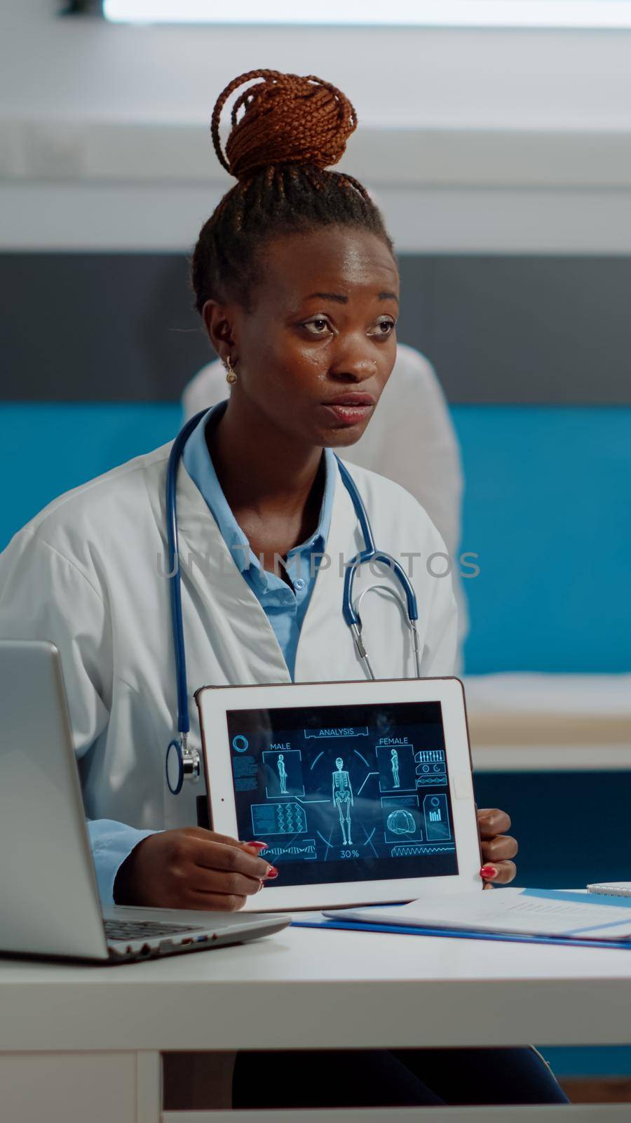 Senior patient and doctor looking at modern tablet by DCStudio