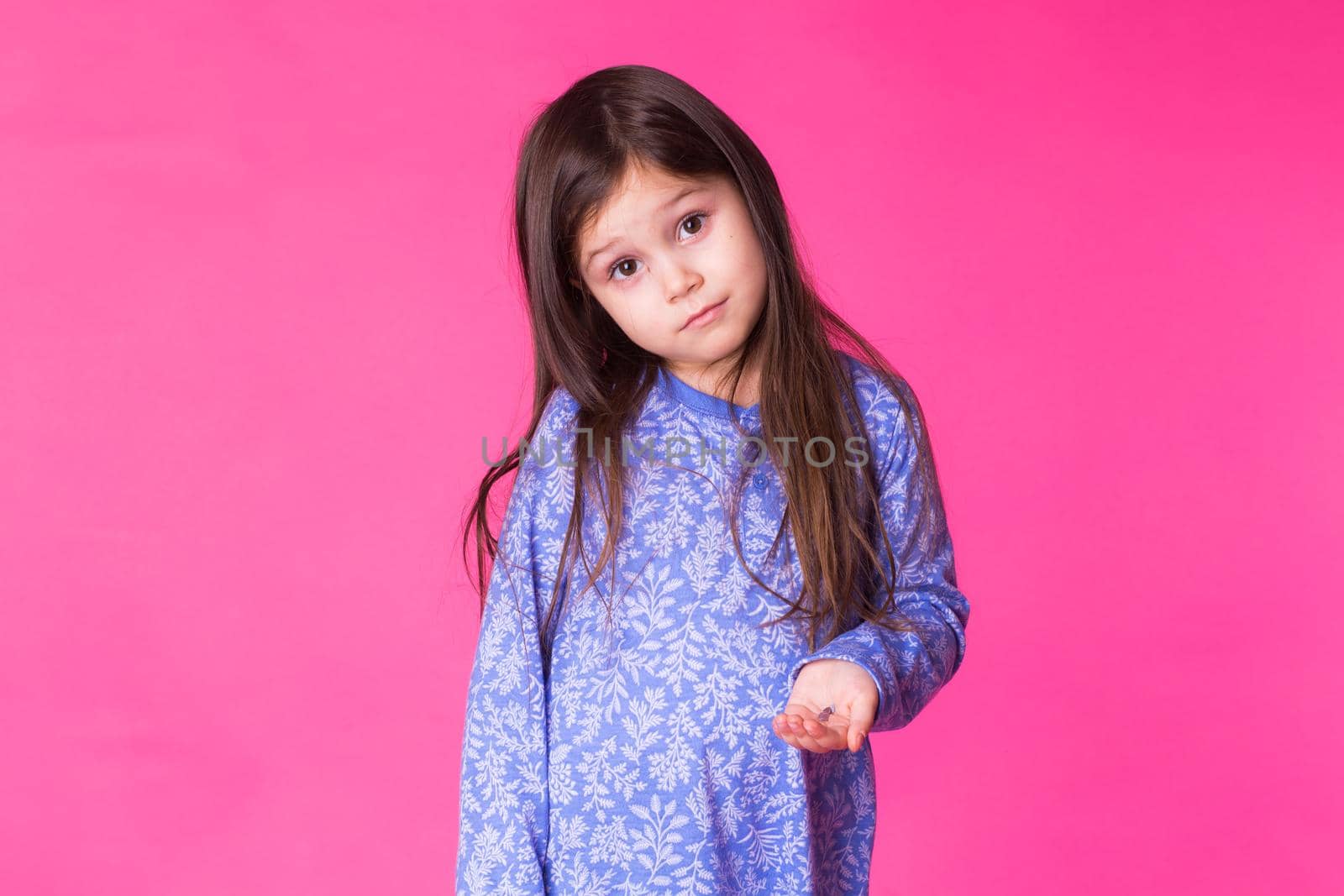 Portrait of adorable little girl isolated on a pink background.