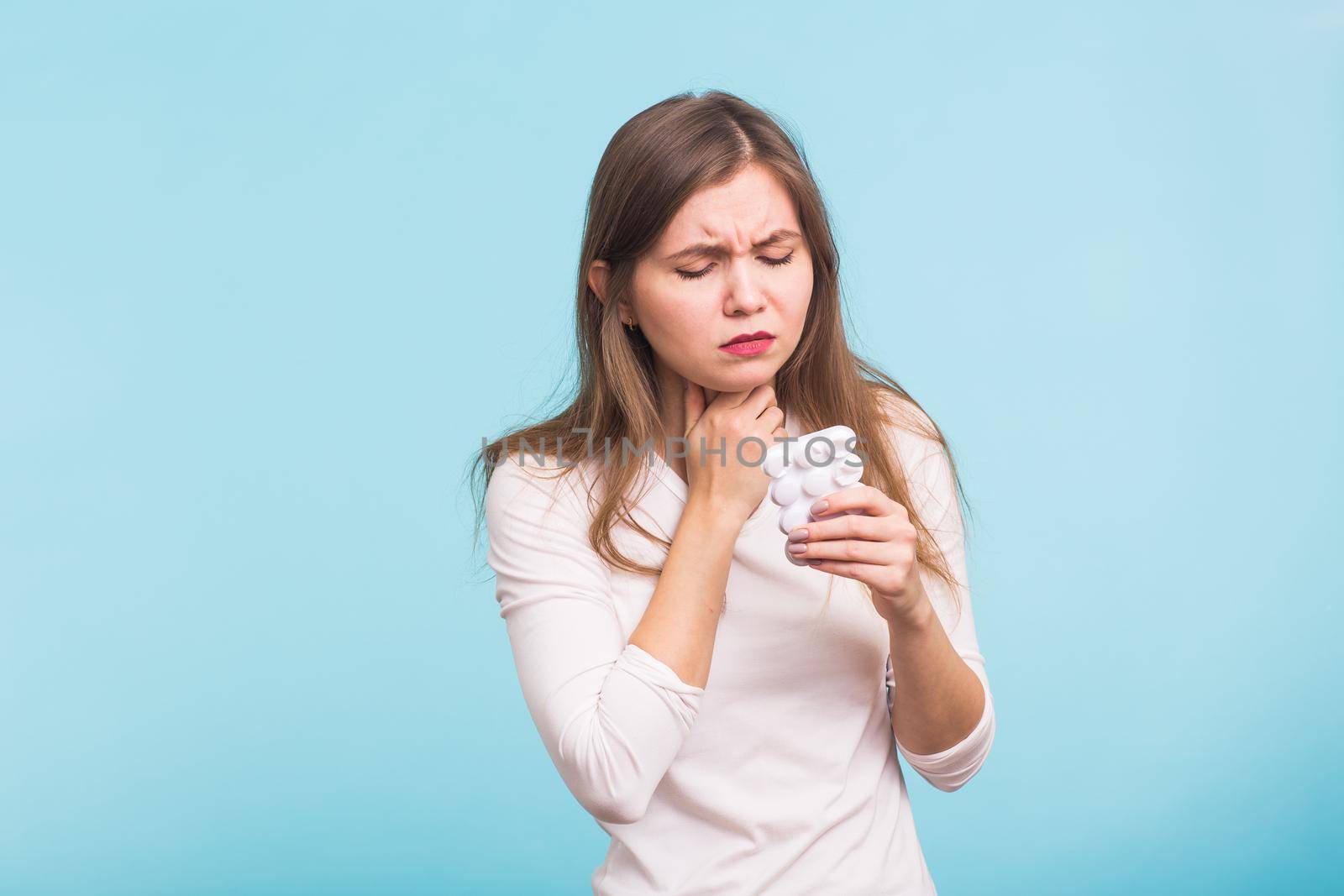 Sore throat. Woman touching the neck on blue background by Satura86