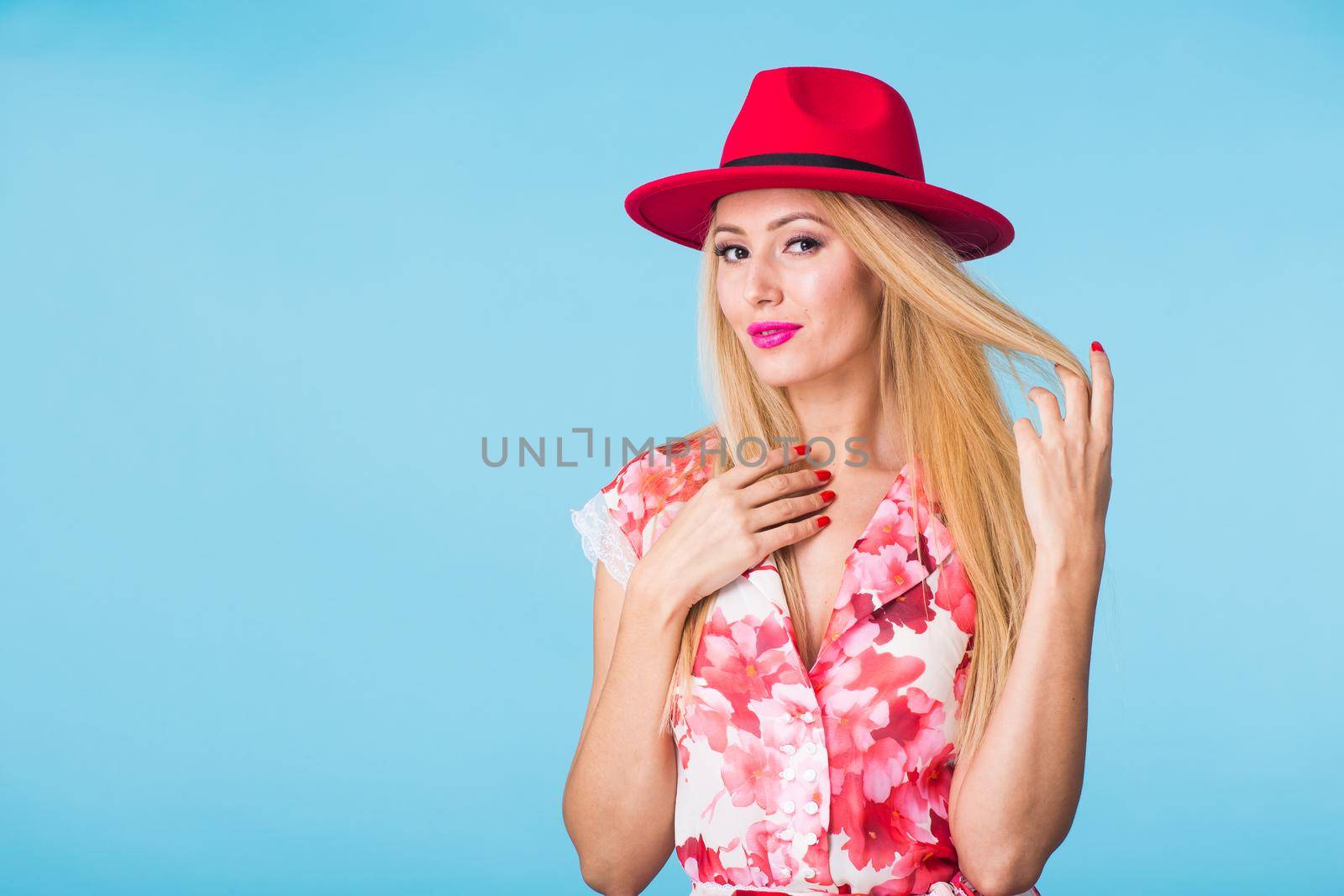 Portrait of happy cheerful smiling young beautiful blond woman on blue background.