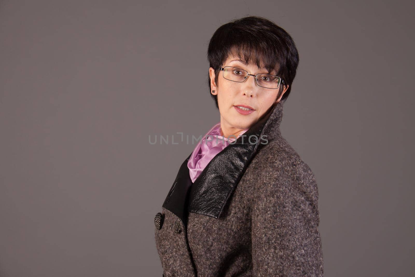 Elegant middle aged woman posing with woolen warm scarf