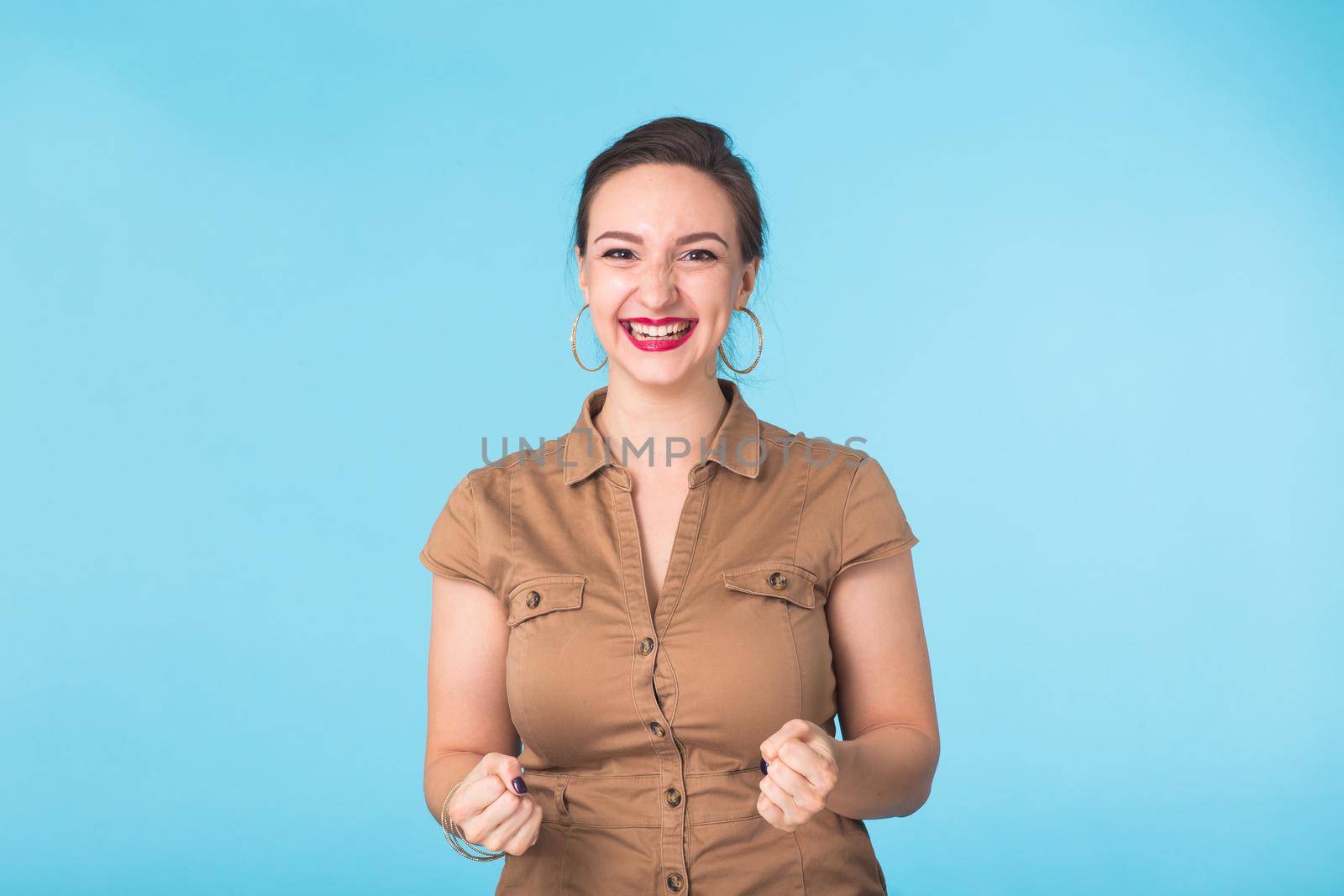 Happy young pretty woman on blue background.