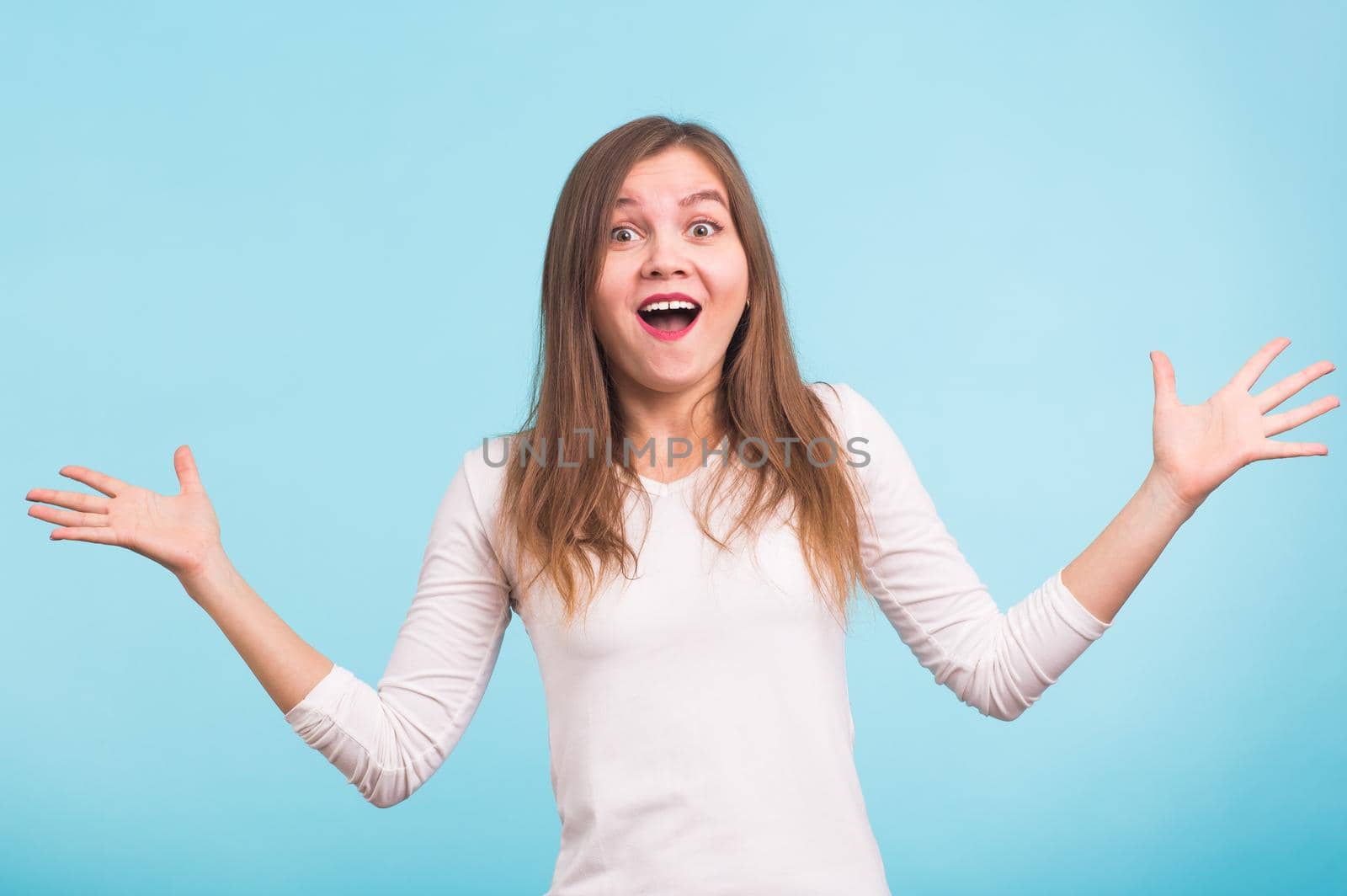 Surprised young woman shouting over blue background. Looking at camera by Satura86