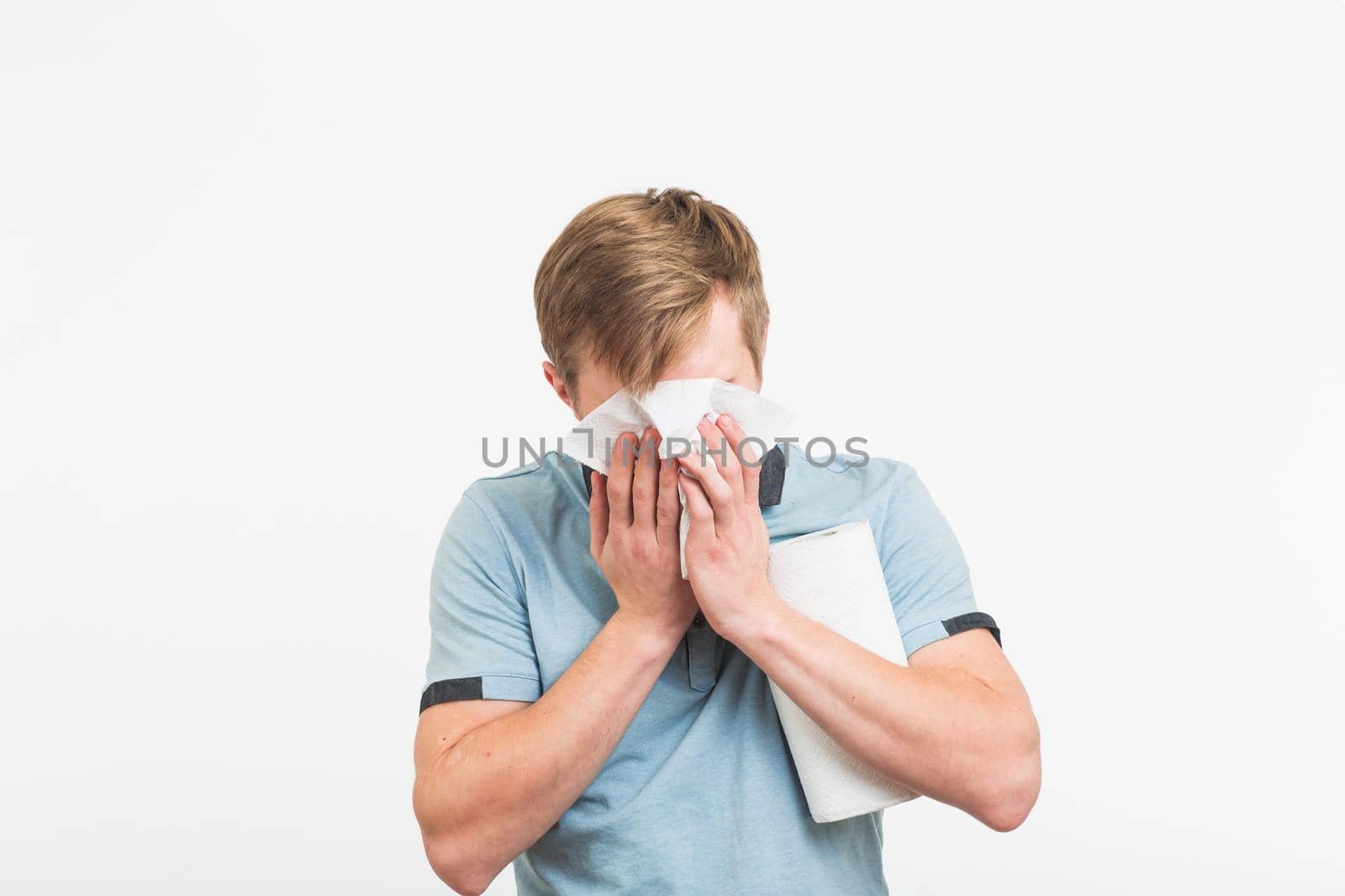 Young man has a runny nose on white background by Satura86