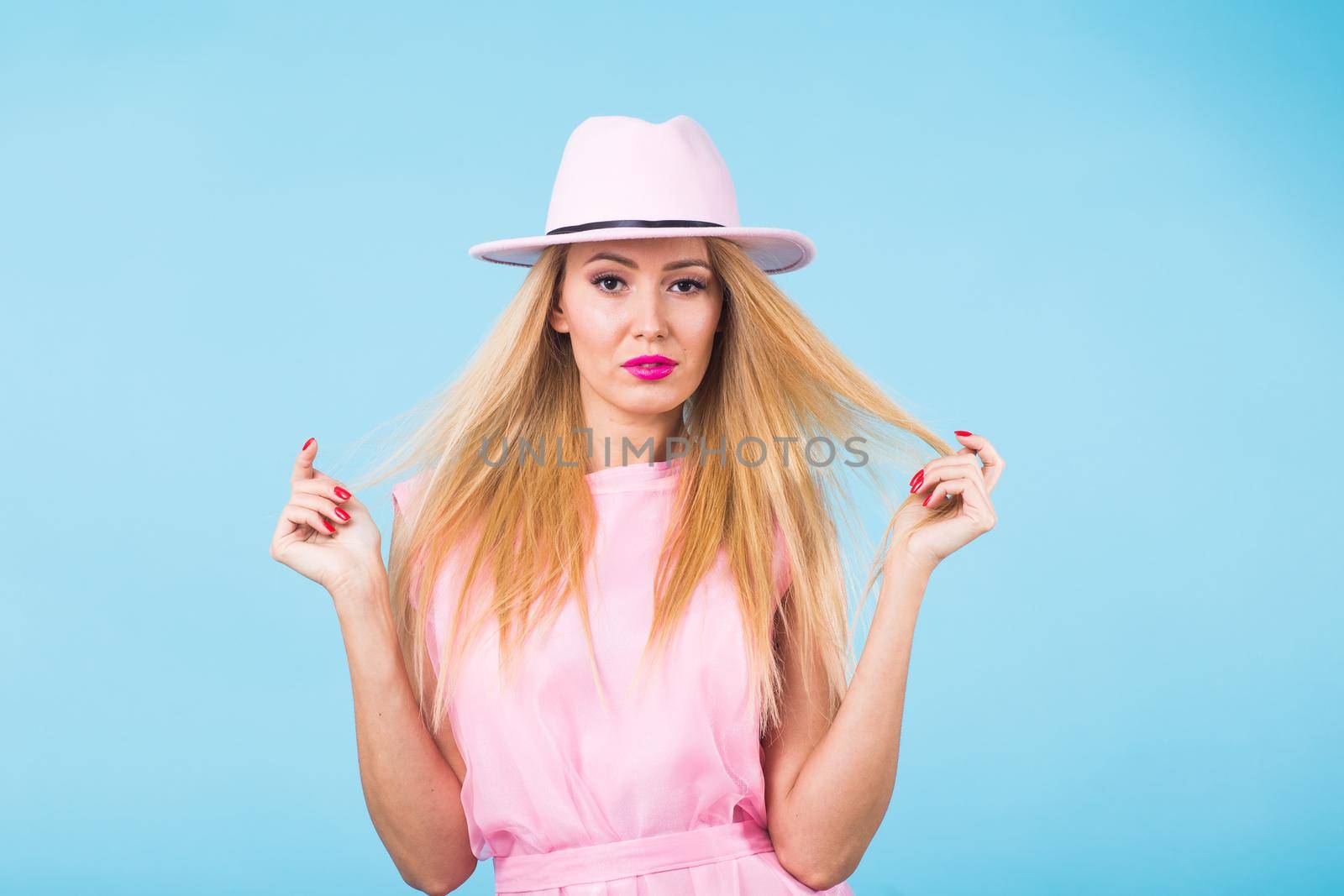 Beautiful woman with long straight blond hair. Fashion model posing at studio.