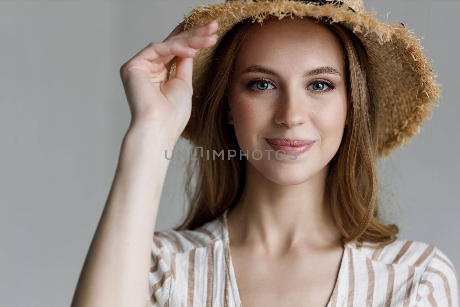 Portrait of a young happy woman in hat in studio by splash