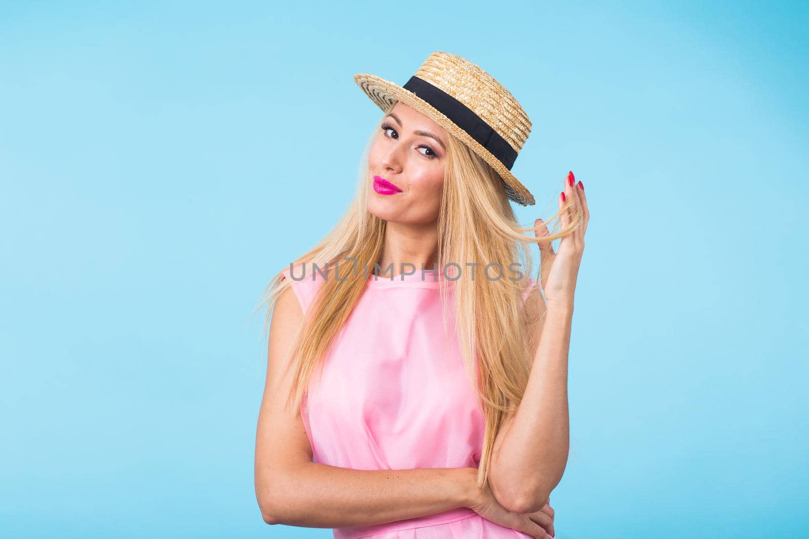 Portrait of smiling blonde woman in fashionable look on blue background. Style, fashion, summer and people concept.