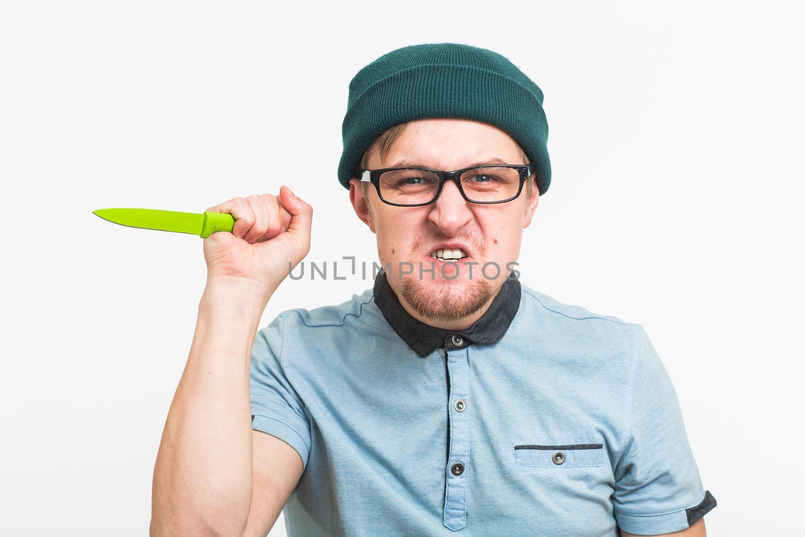 Young angry man holding a knife isolated on a white background.