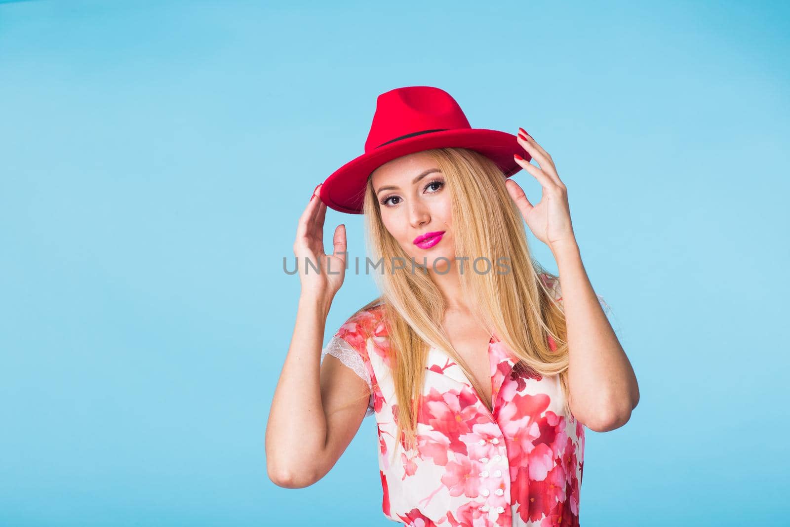 Portrait of happy cheerful smiling young beautiful blond woman on blue background.