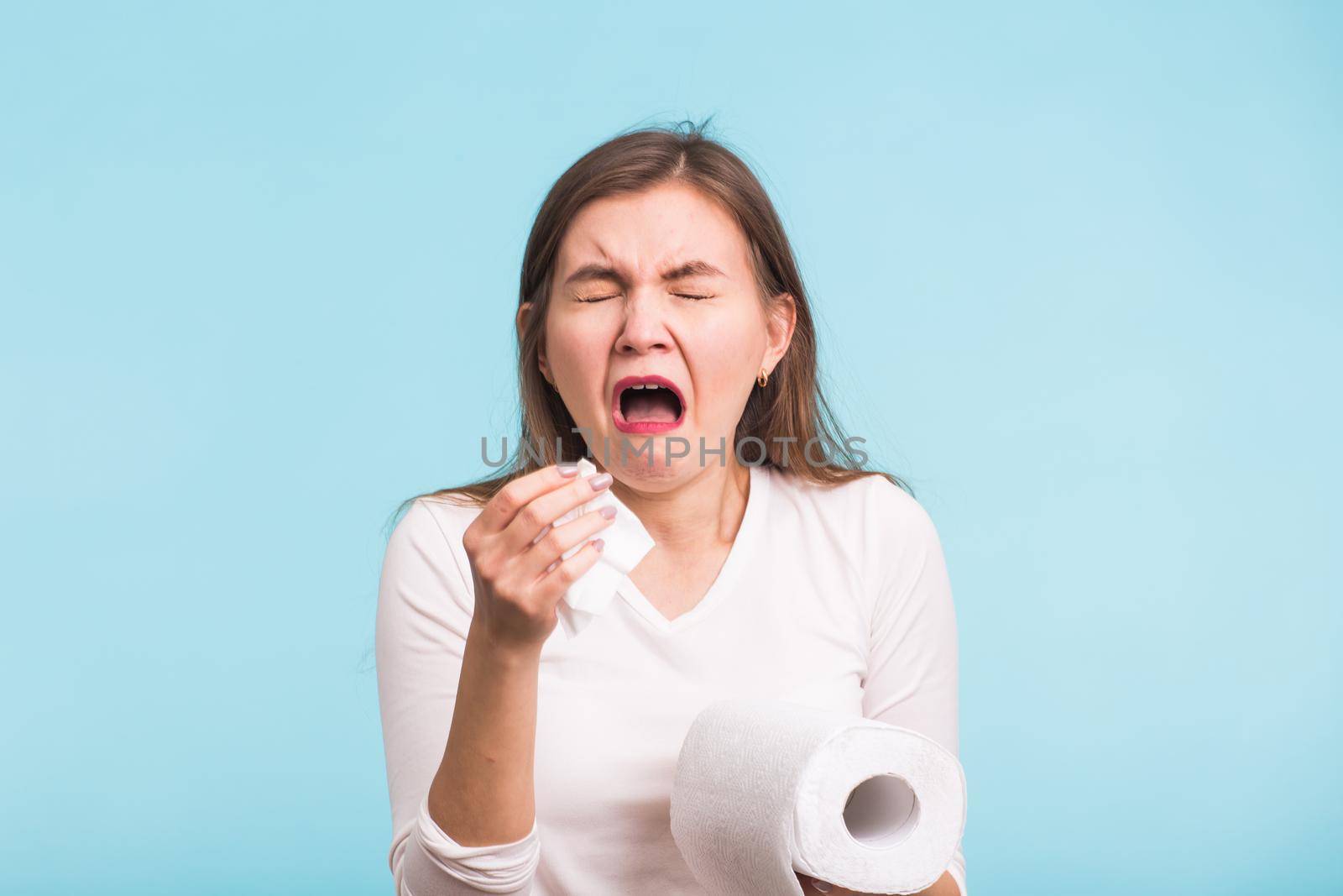 Woman Sneezing Studio Portrait Concept on blue background.