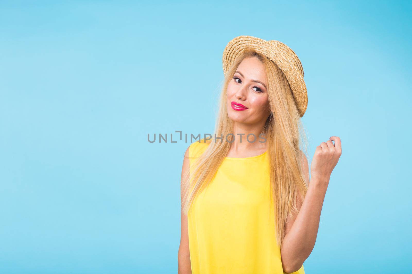 Beautiful woman with long straight blond hair. Fashion model posing at studio on blue background by Satura86