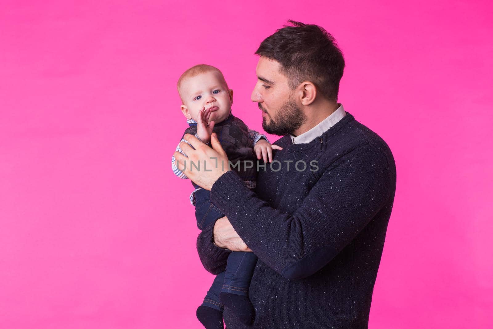 Happy portrait of the father and son on pink background. In studio by Satura86