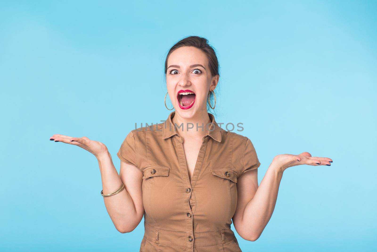 Portrait of young emotional woman cheerful smiling looking at camera. Isolated on pastel blue background. Copy space. by Satura86