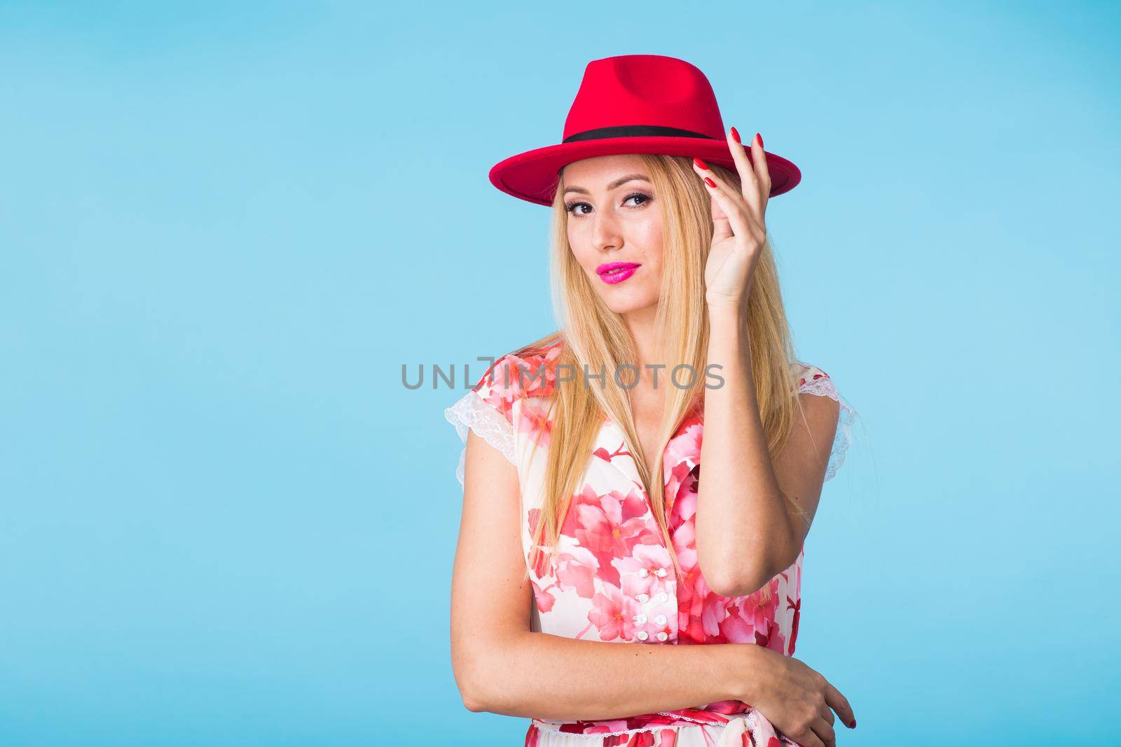 Beautiful woman with long straight blond hair. Fashion model posing at studio on blue background with copyspace by Satura86