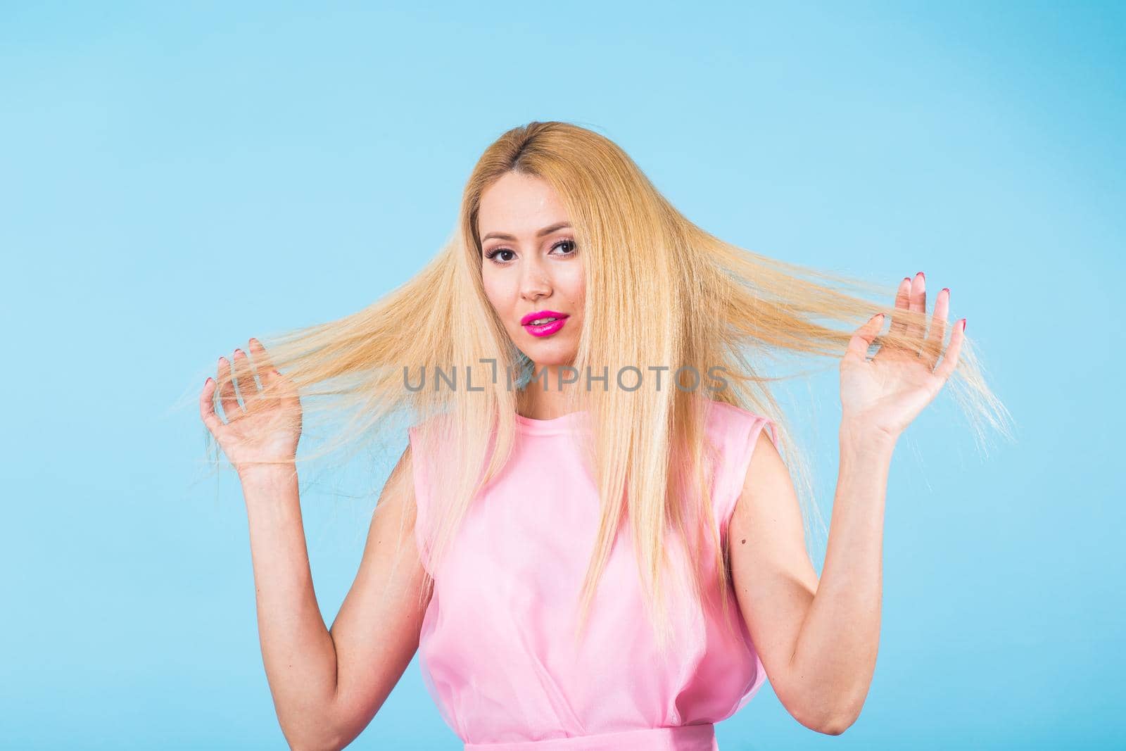 Portrait of happy cheerful smiling young beautiful blond woman on blue background by Satura86