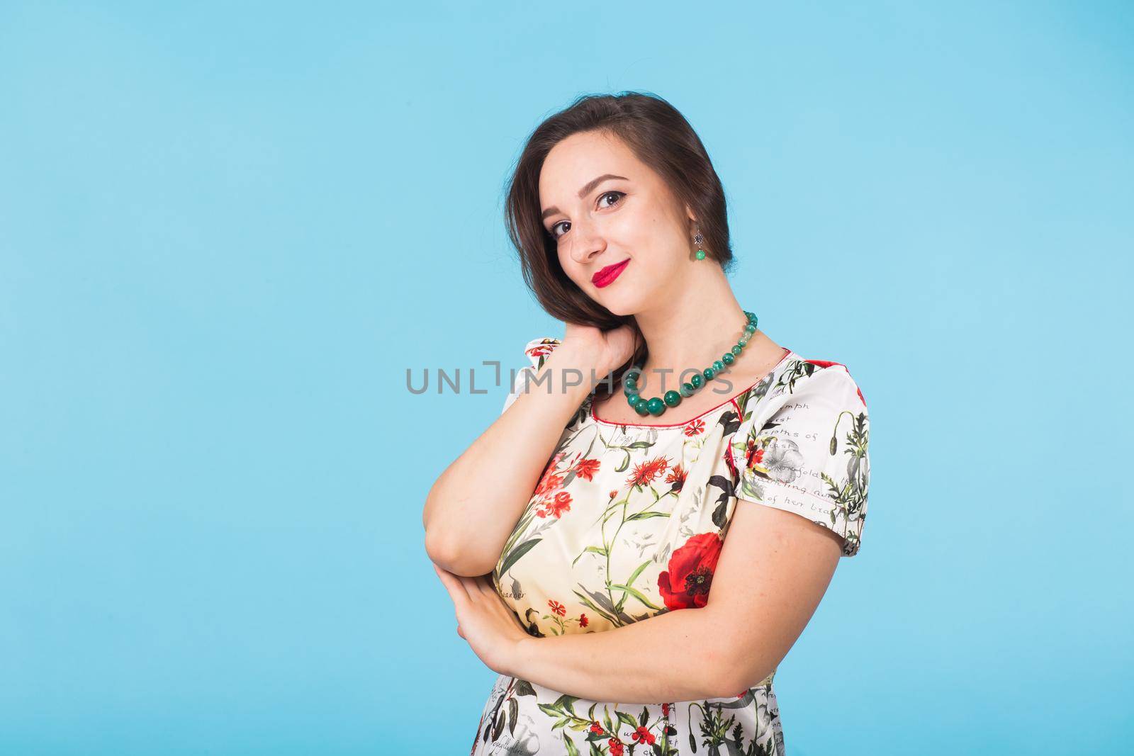 Portrait of young beautiful ginger woman with freckles cheerfuly smiling looking at camera. Isolated on pastel blue background. Copy space.