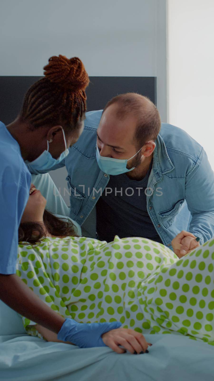 Multi ethnic people helping with childbirth in hospital ward by DCStudio