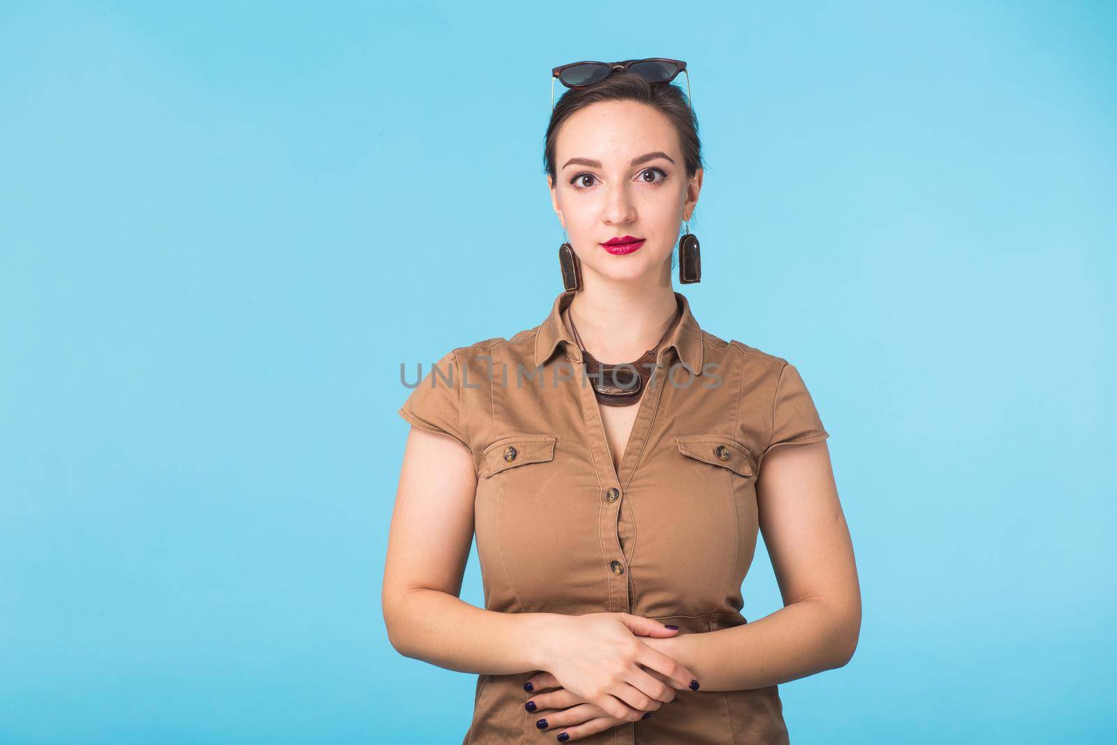 Portrait of young beautiful woman cheerfuly smiling looking at camera. Isolated on pastel blue background. Copy space. by Satura86