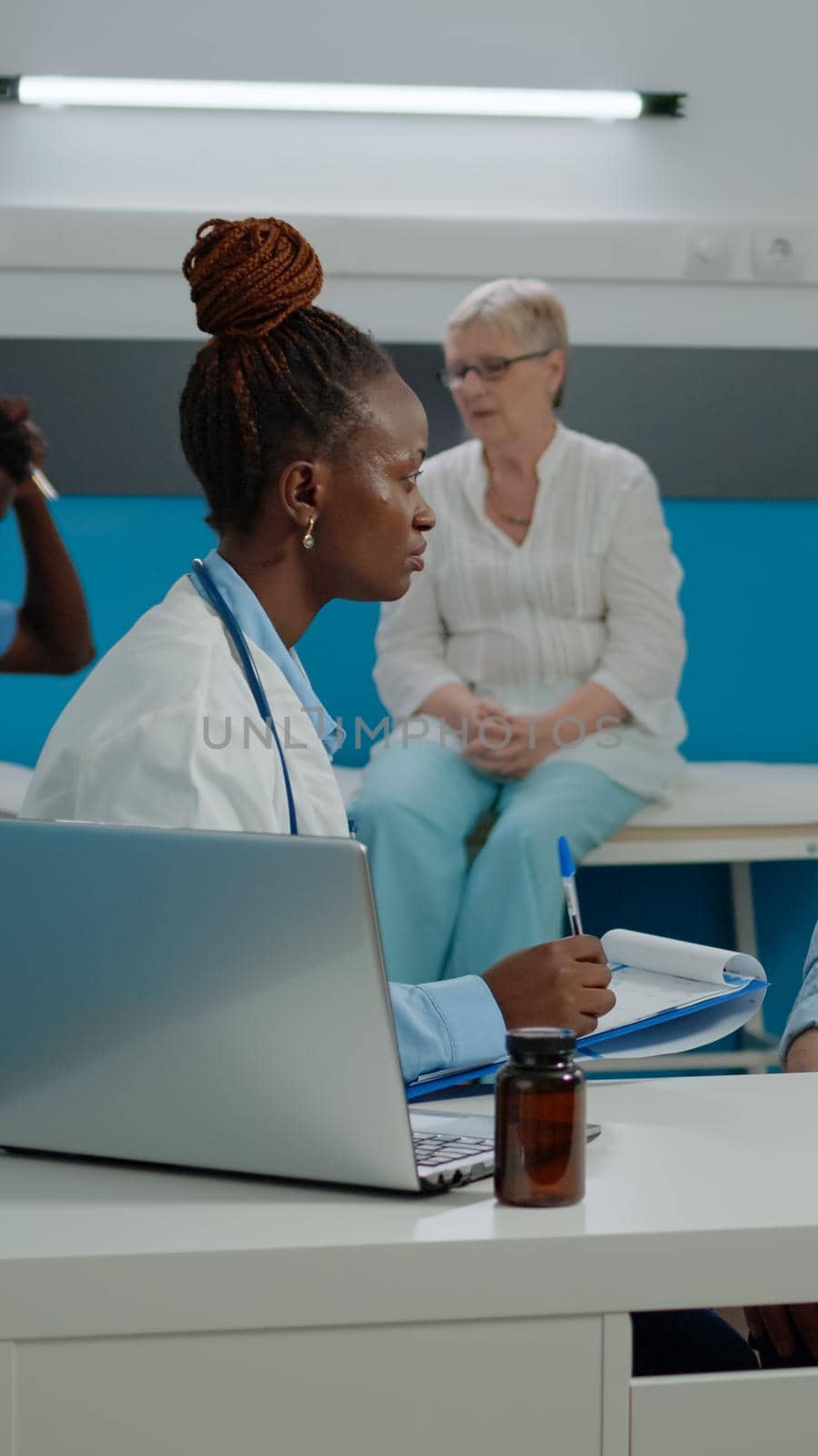 Doctor checking on elder patient healthcare in medical cabinet by DCStudio