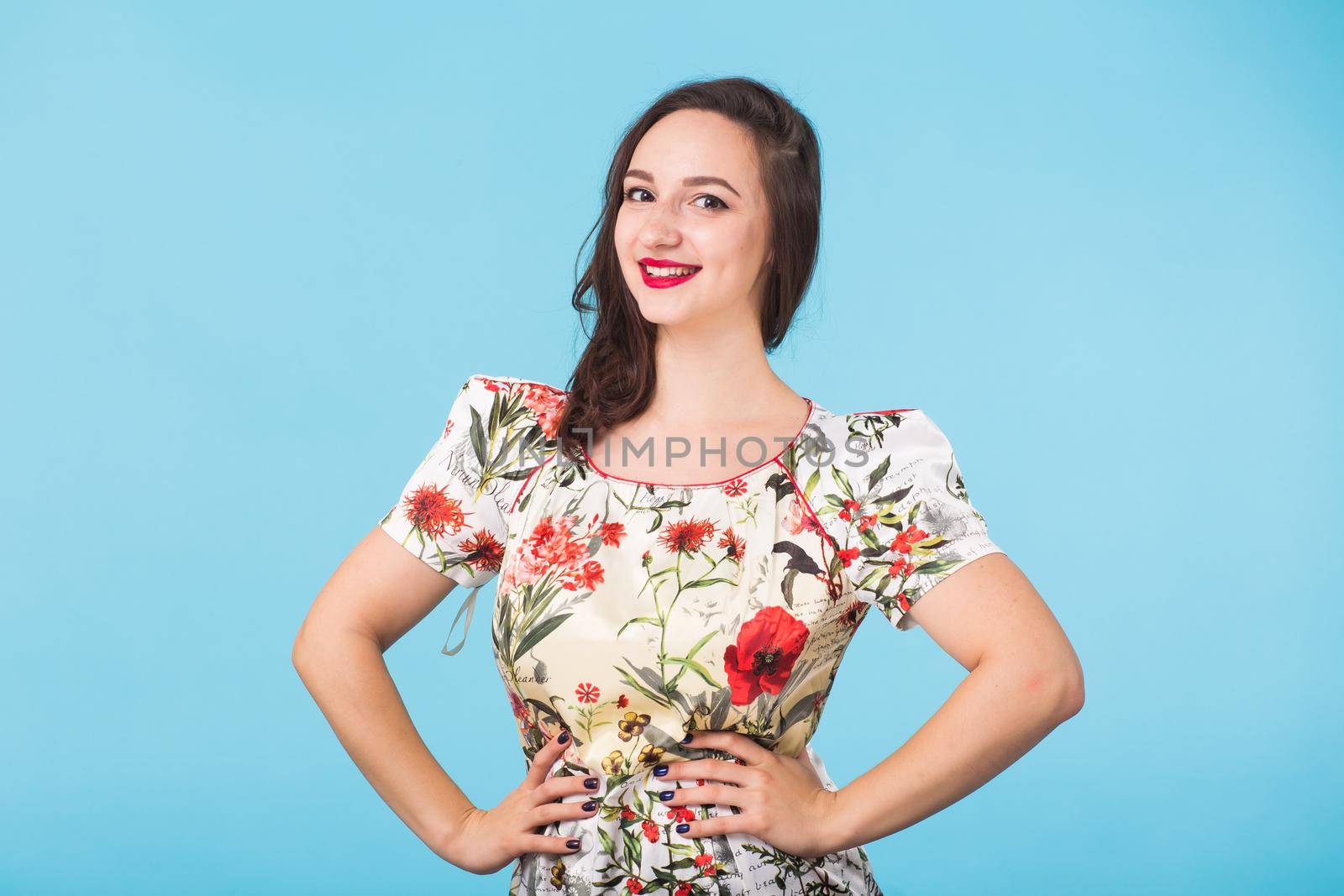 Portrait of young beautiful ginger woman with freckles cheerfuly smiling looking at camera. Isolated on pastel blue background. Copy space.