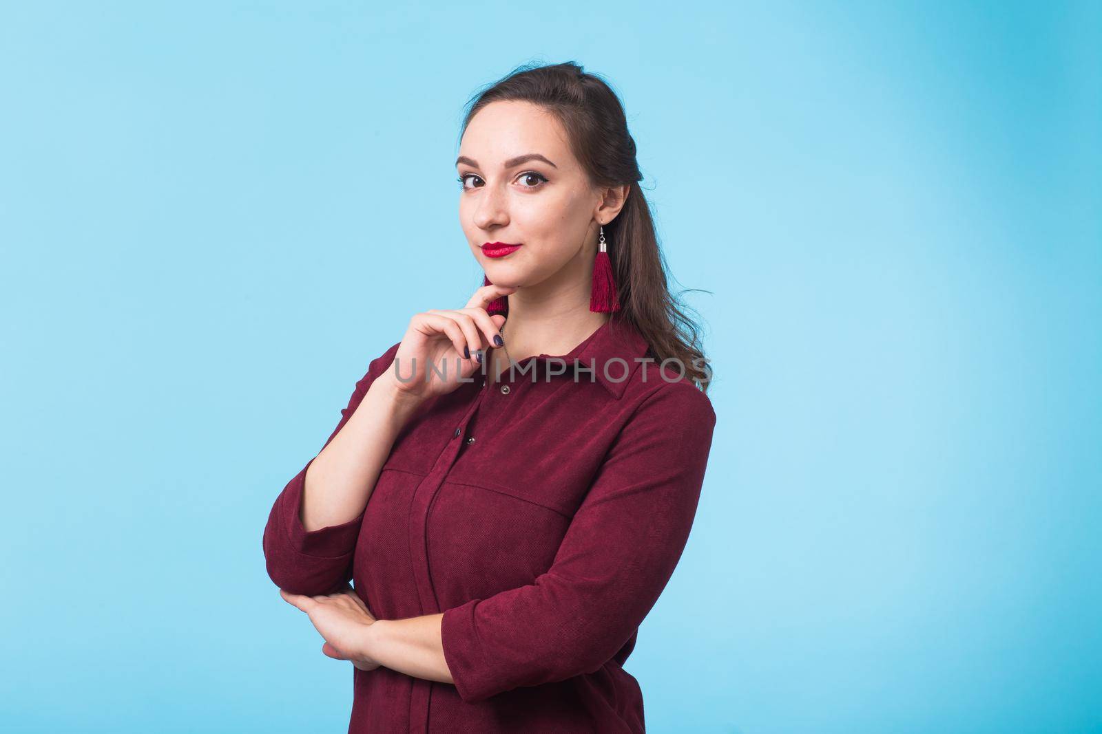 Portrait of young beautiful woman cheerfuly smiling looking at camera. Isolated on pastel blue background. Copy space. by Satura86