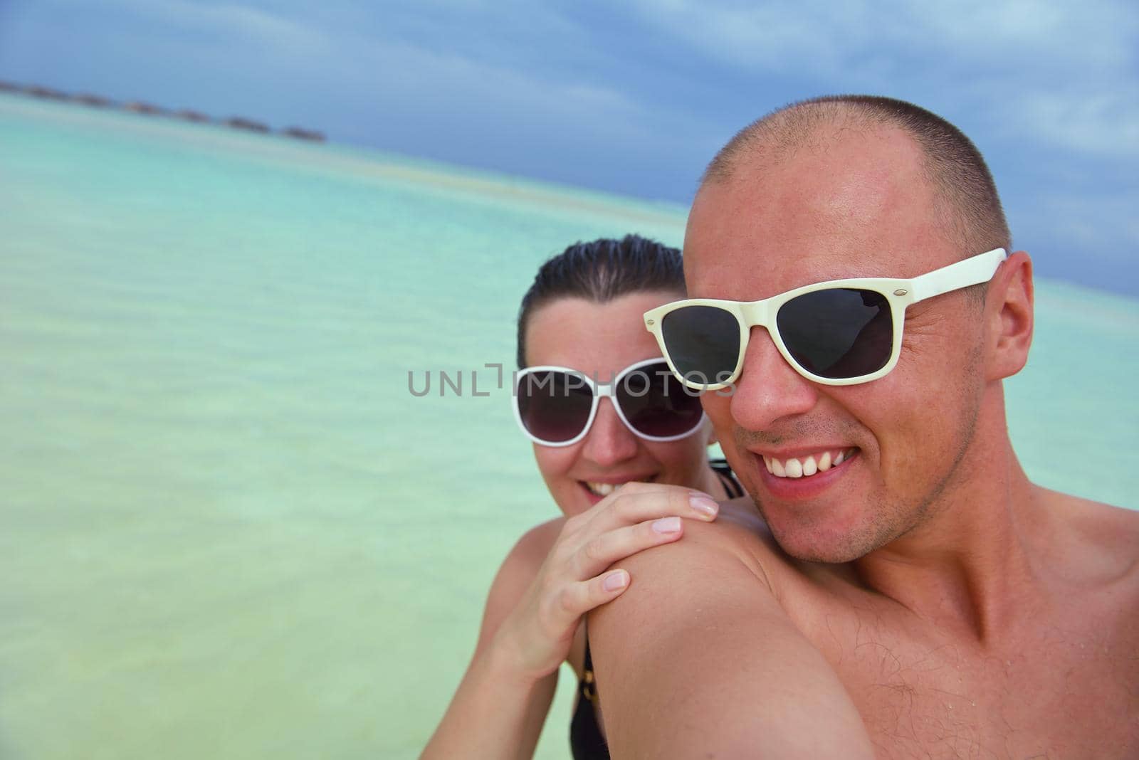 happy young couple have fun on beach by dotshock