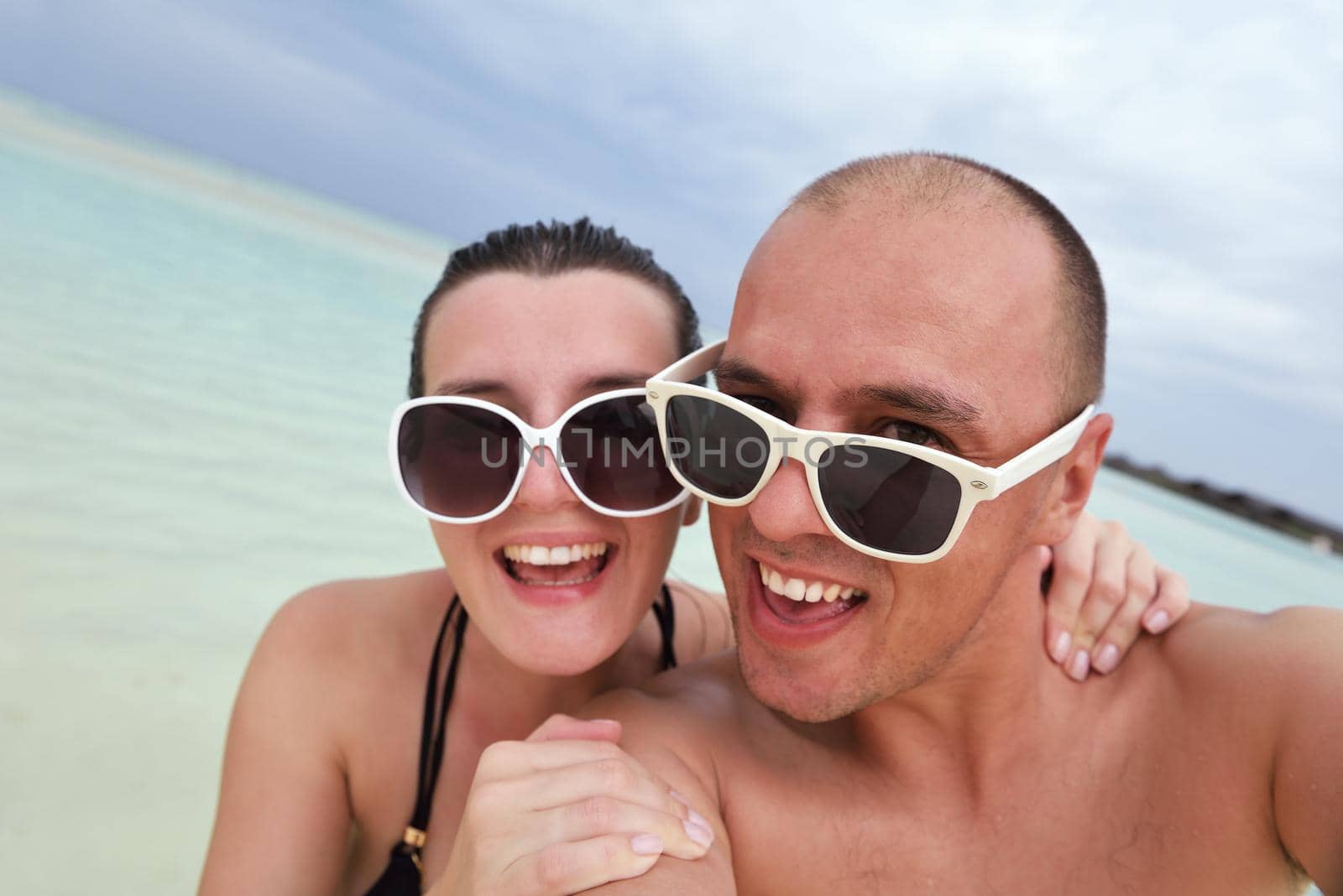 happy young couple have fun on beach by dotshock