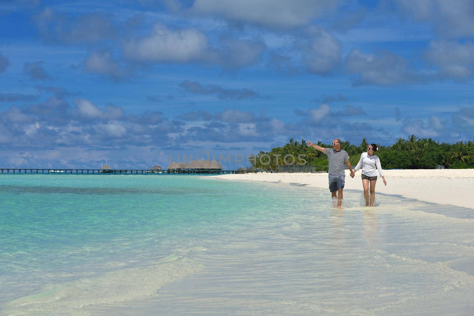 happy young couple have fun on beach by dotshock