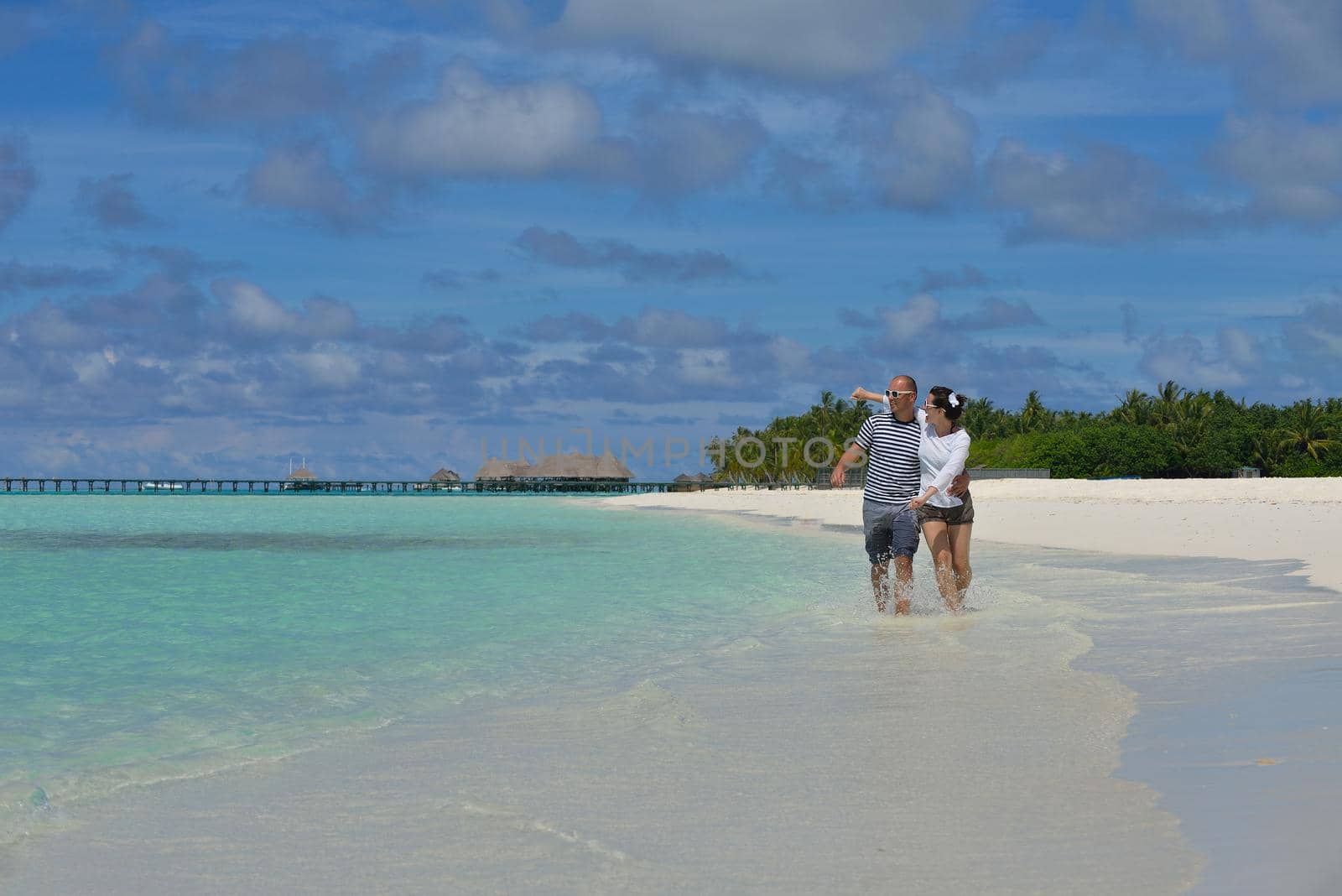 happy young couple have fun on beach by dotshock