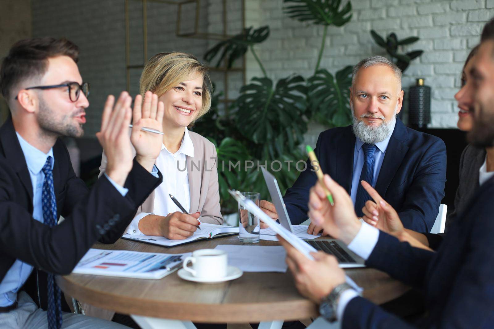 Team of business people having discussion at table in creative office