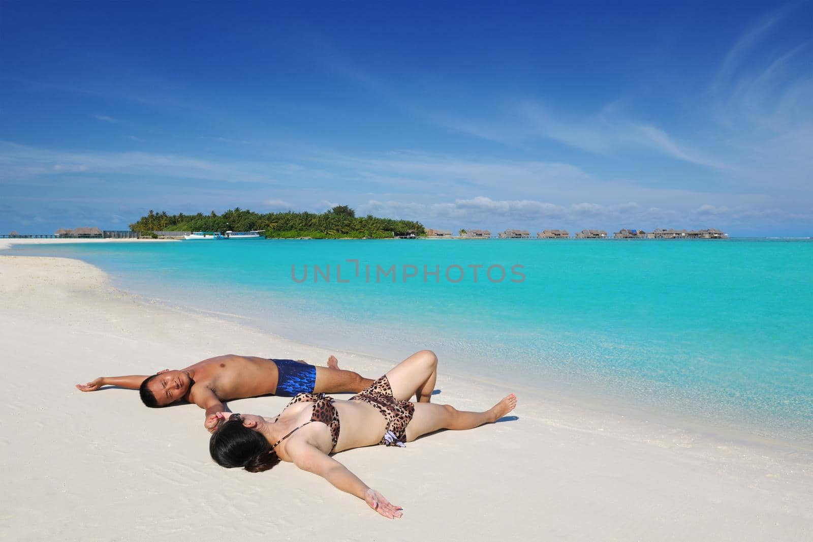 happy young asian couple enjoying summer and have on beautiful white sand beach