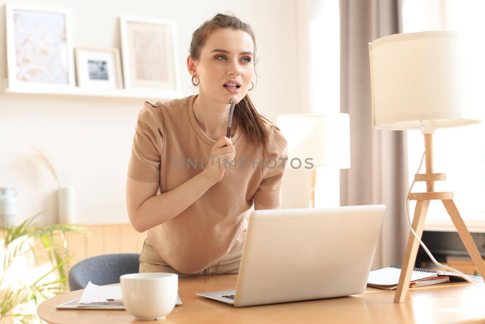 Young business woman standing in her home office reading notes