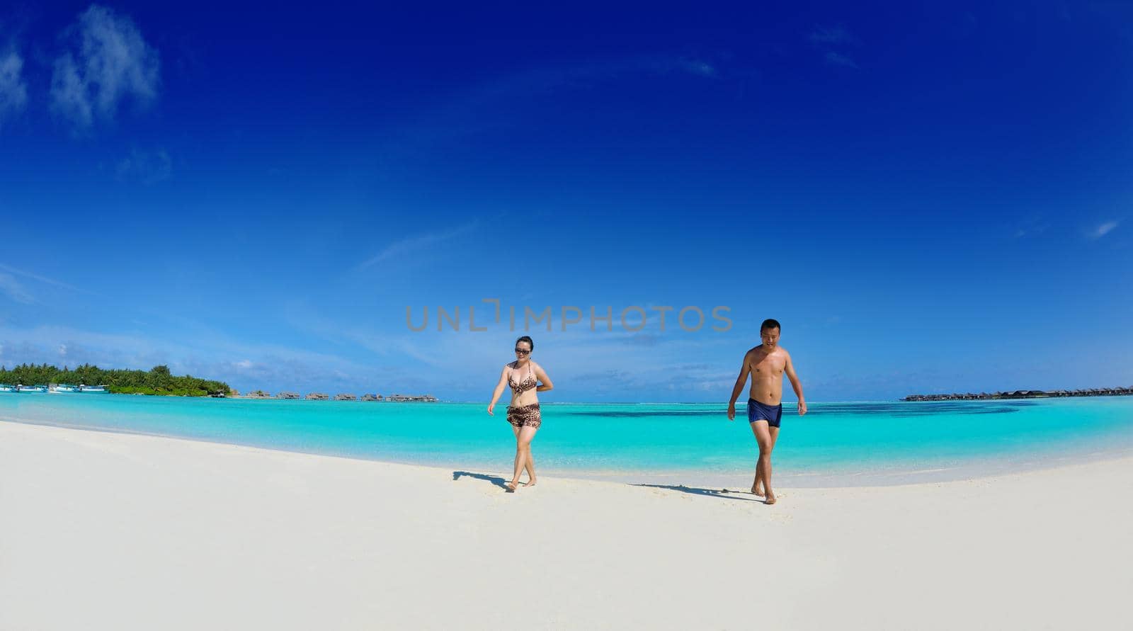 happy young  couple enjoying summer on beach by dotshock