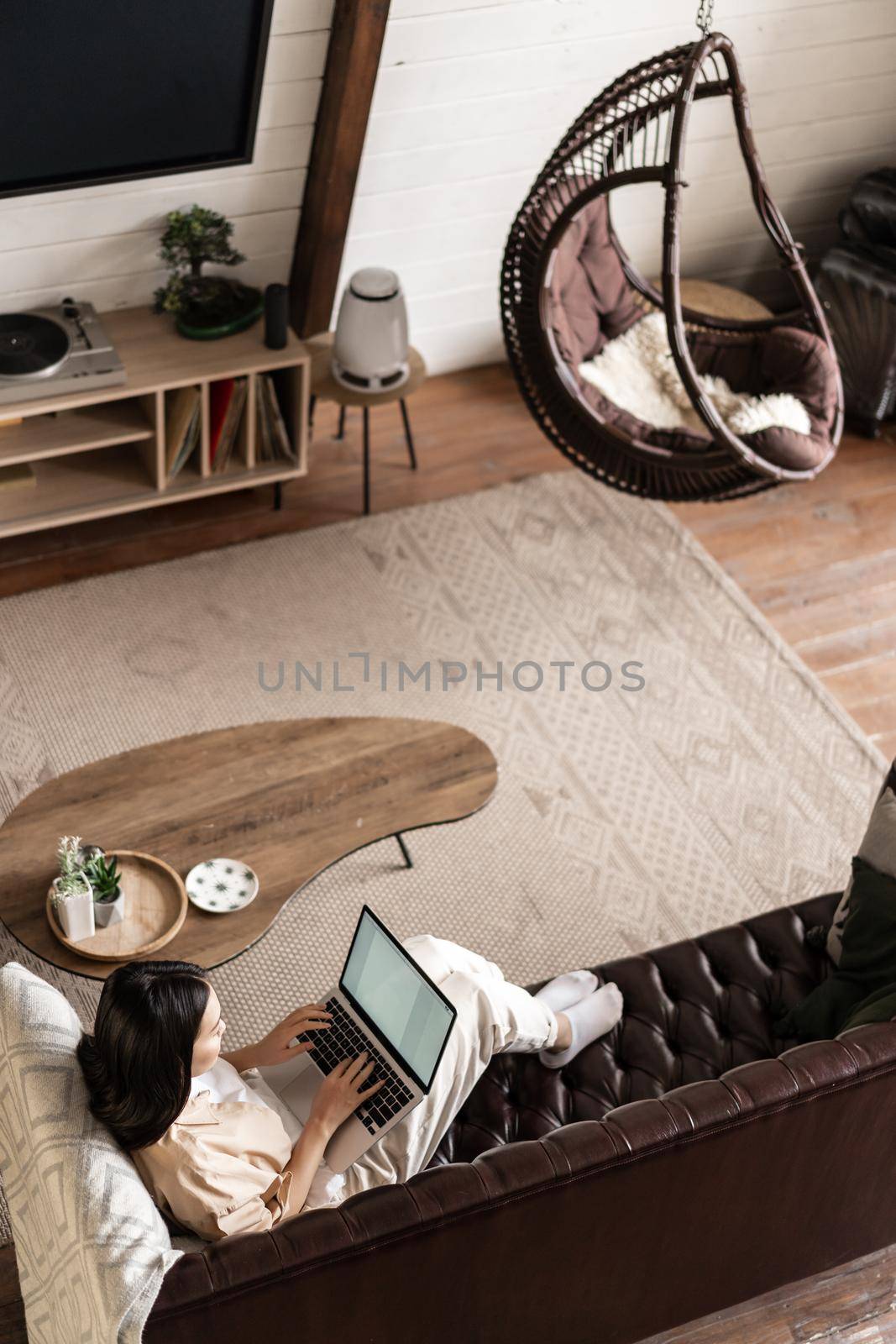 Vertical shot of asian girl student studying at home on sofa, laying on couch and using laptop computer.