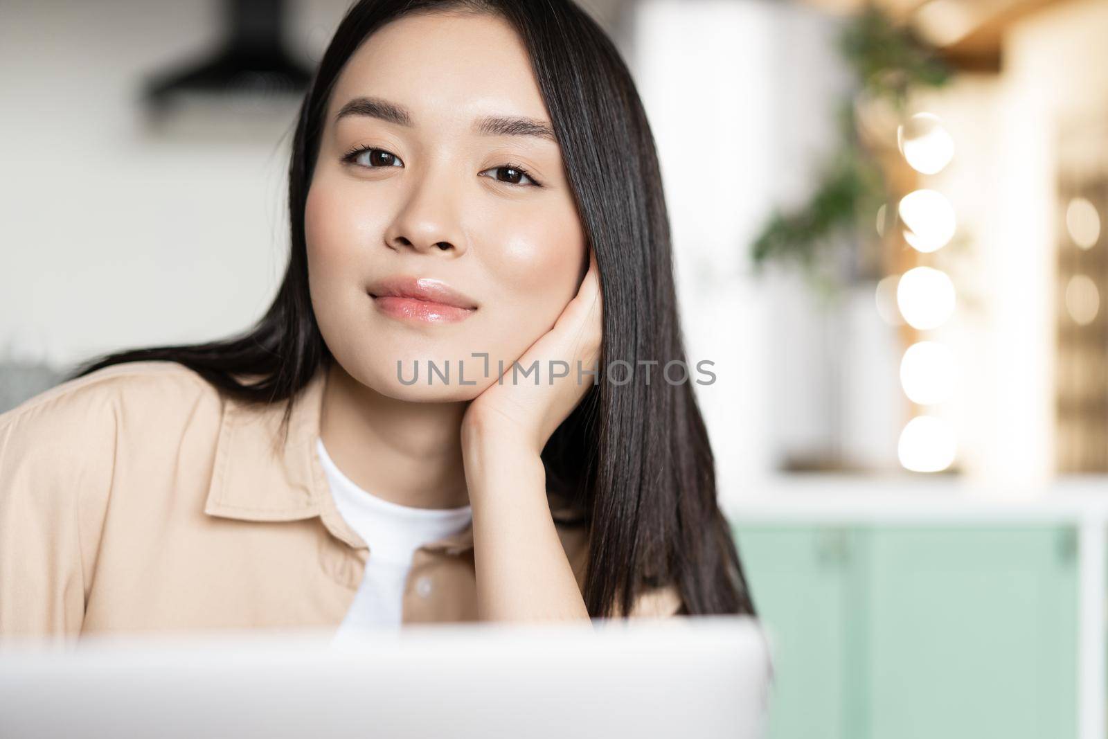 Portrait of asian smiling woman with laptop at home.