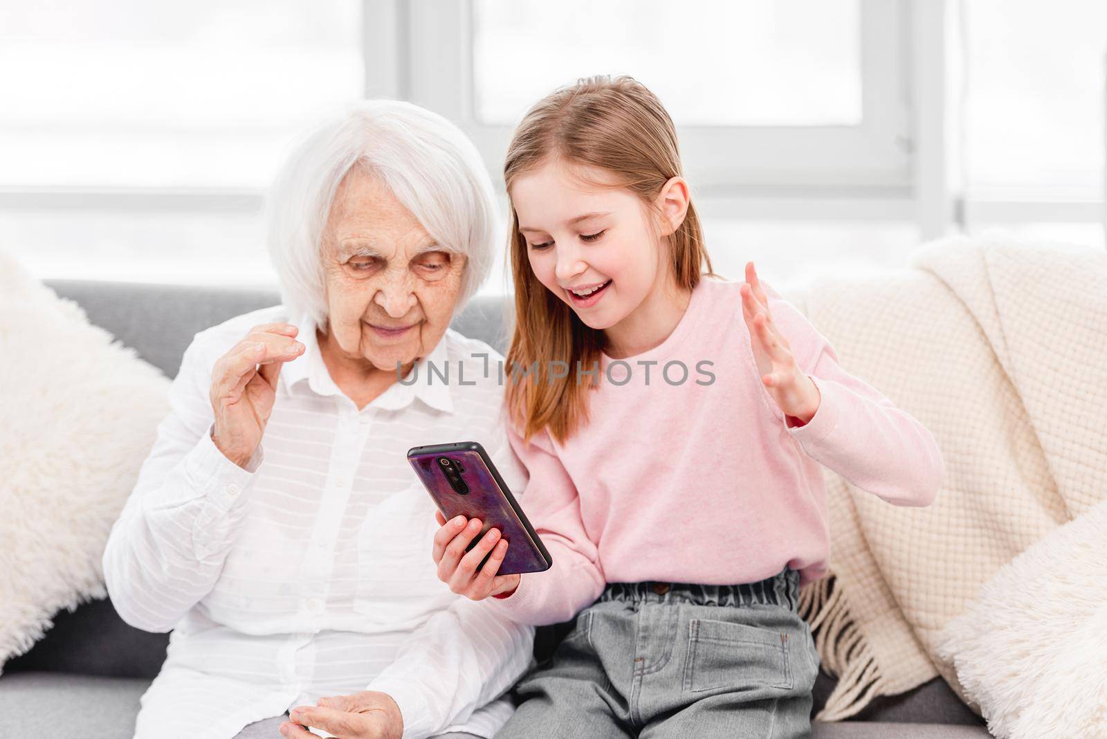 Grandmother with grandaughter using smartphone by tan4ikk1
