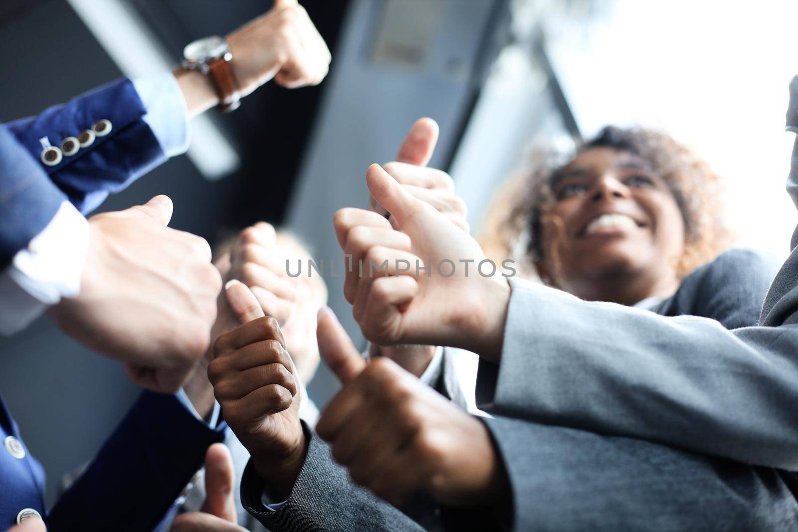 closeup portrait of business people giving thumbs up