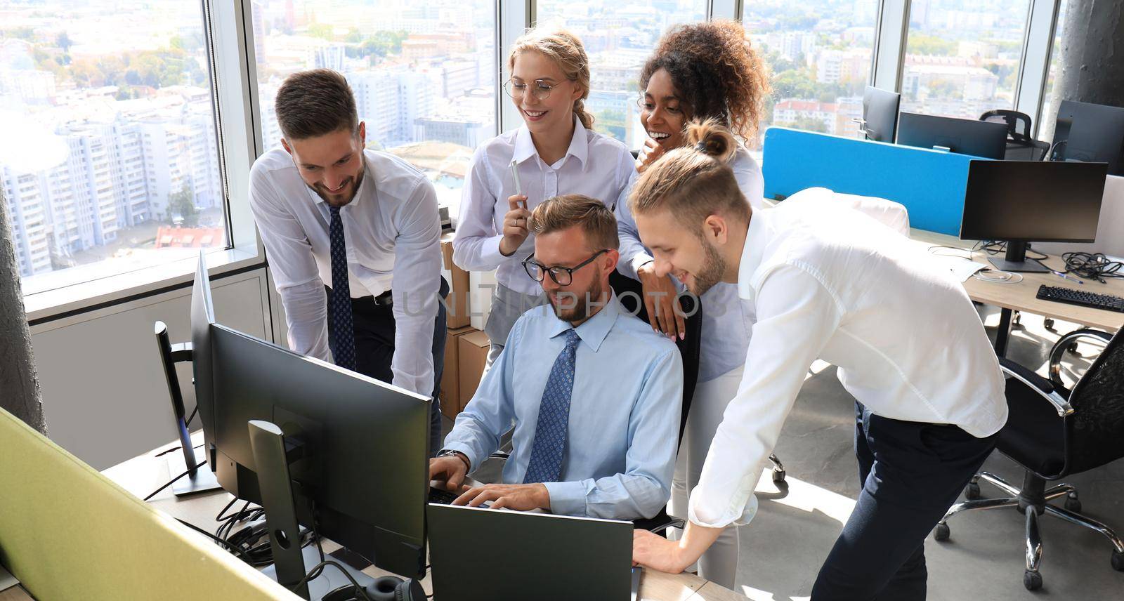 Group of young modern people in formalwear using modern technologies while working in the creative office.