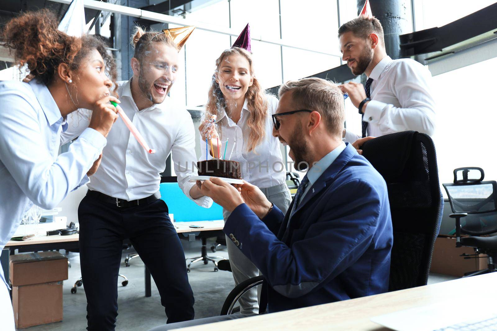 Business team celebrating a birthday of collegue in the modern office.