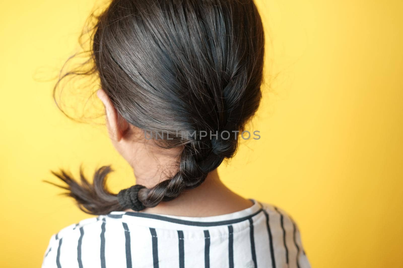 child girl with long hair against yellow background