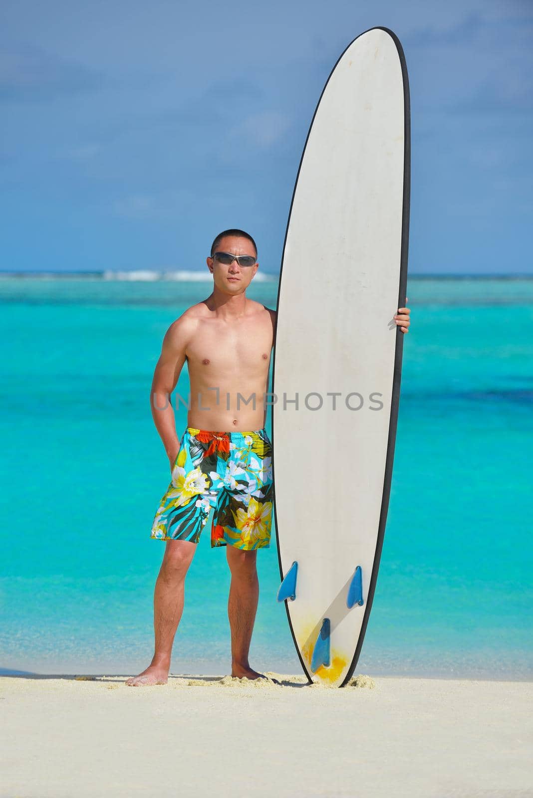 Man with surf board on beach by dotshock