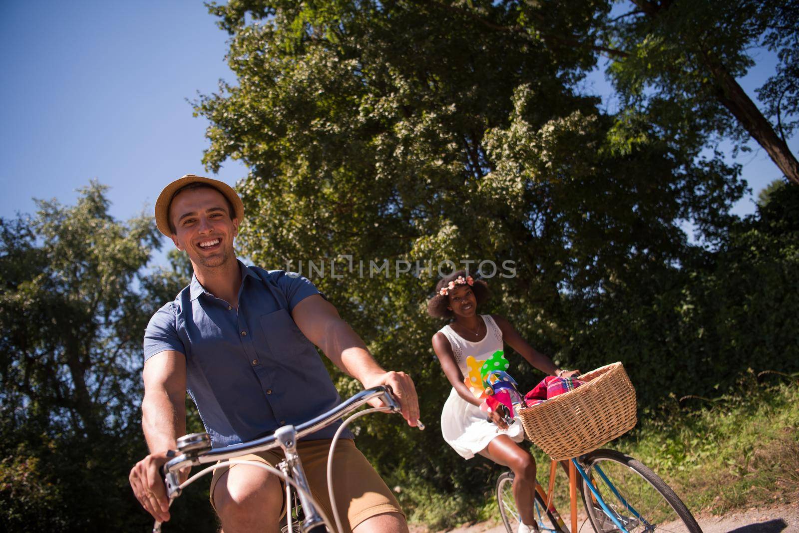 a young man and a beautiful African American girl enjoying a bike ride in nature on a sunny summer day