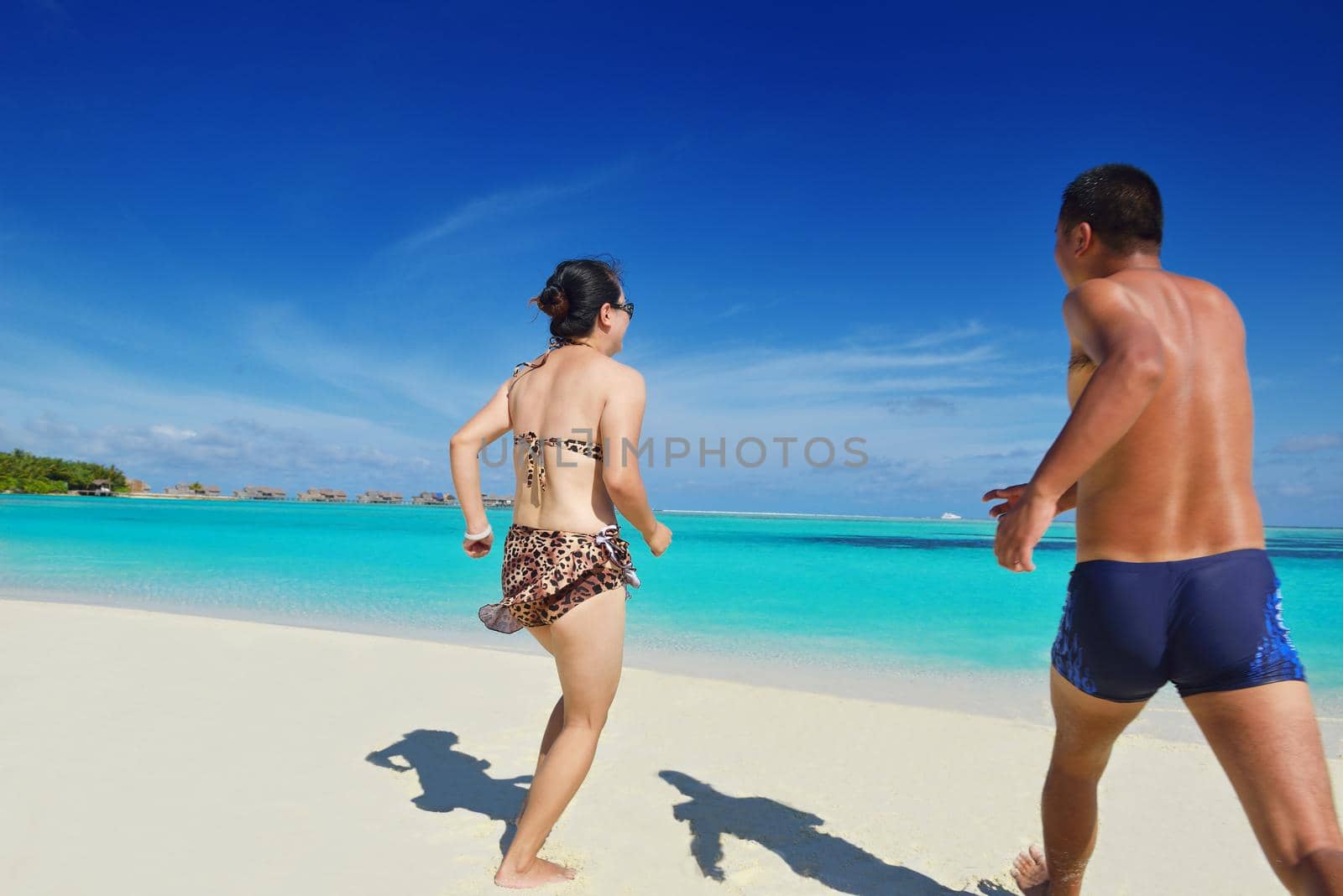 happy young  couple enjoying summer on beach by dotshock