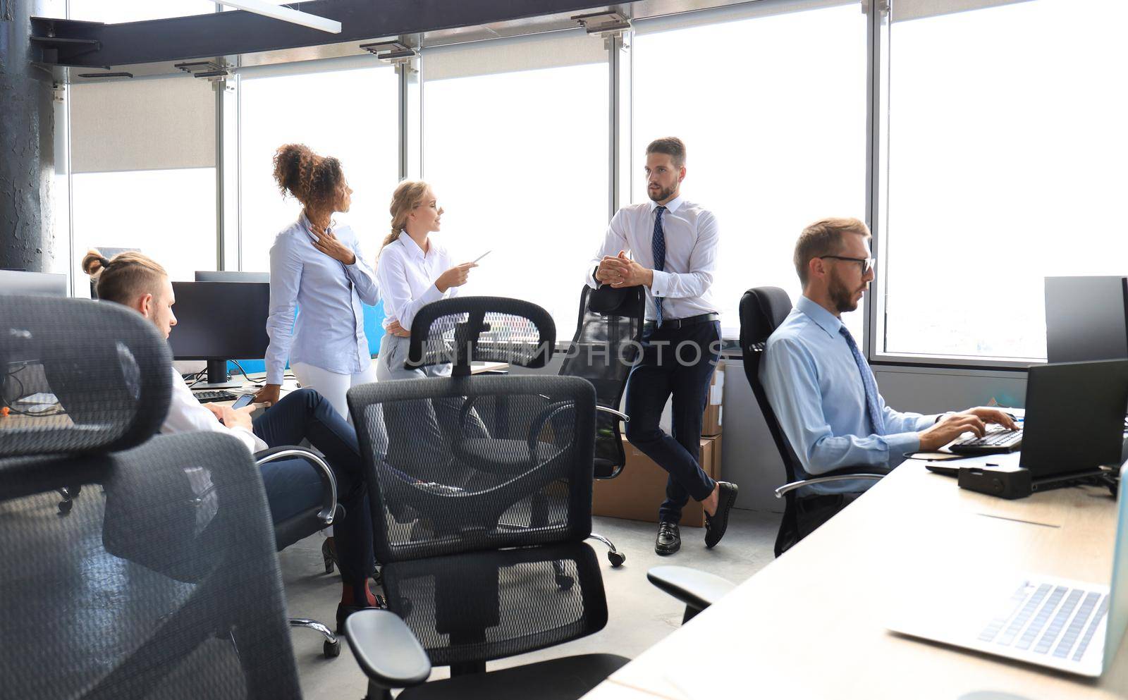 Group of young business people discussing something while working in the creative office.